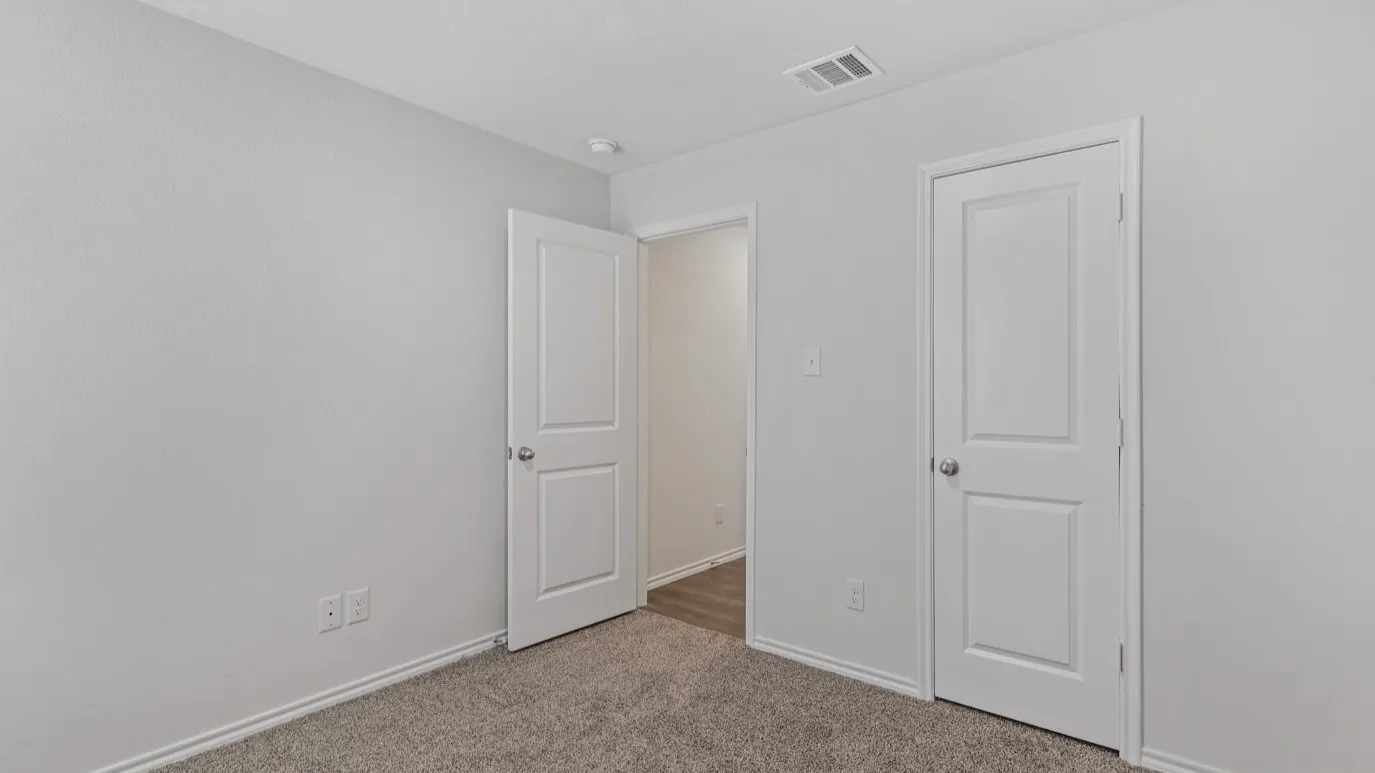 Neutral tone wall paint with textured finish, two-panel interior doors, light-colored carpeting, and recessed ceiling lighting