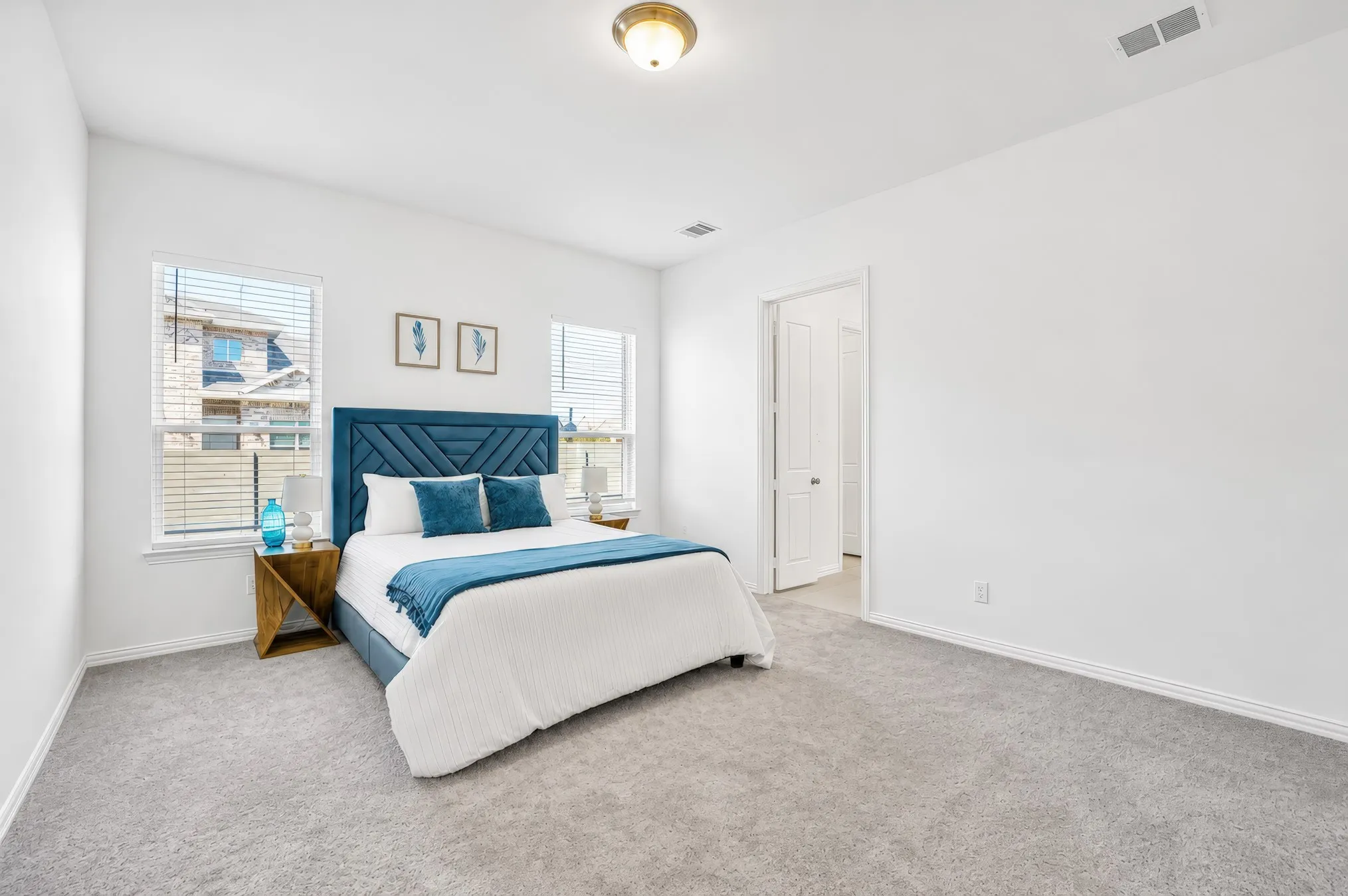 Recessed lighting, light gray carpeting, crisp white walls, and a white interior door