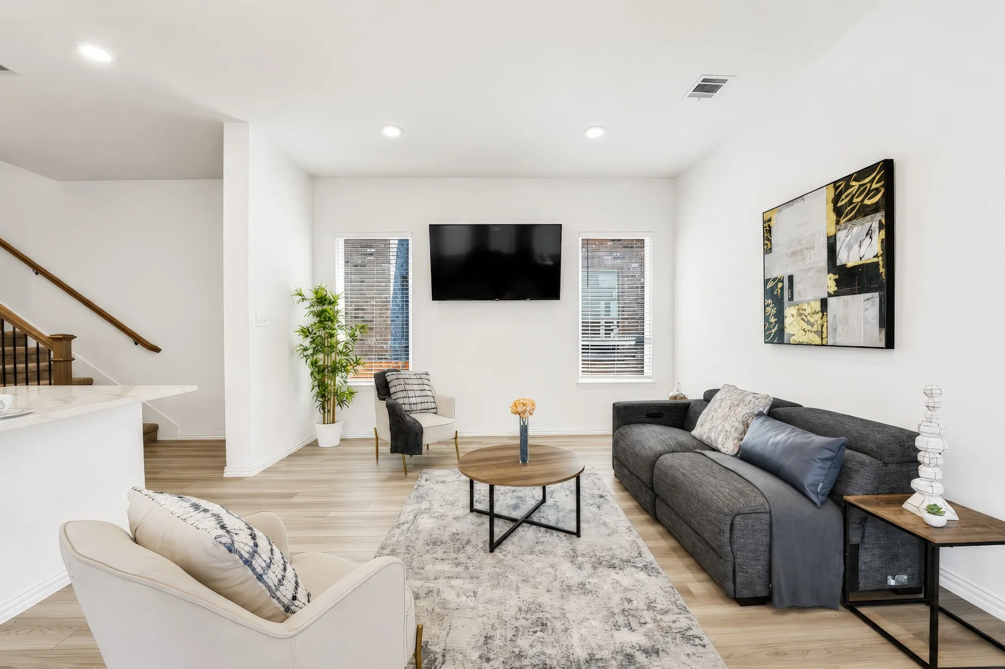 Open-concept living area featuring wood-finish flooring, recessed lighting, and white walls