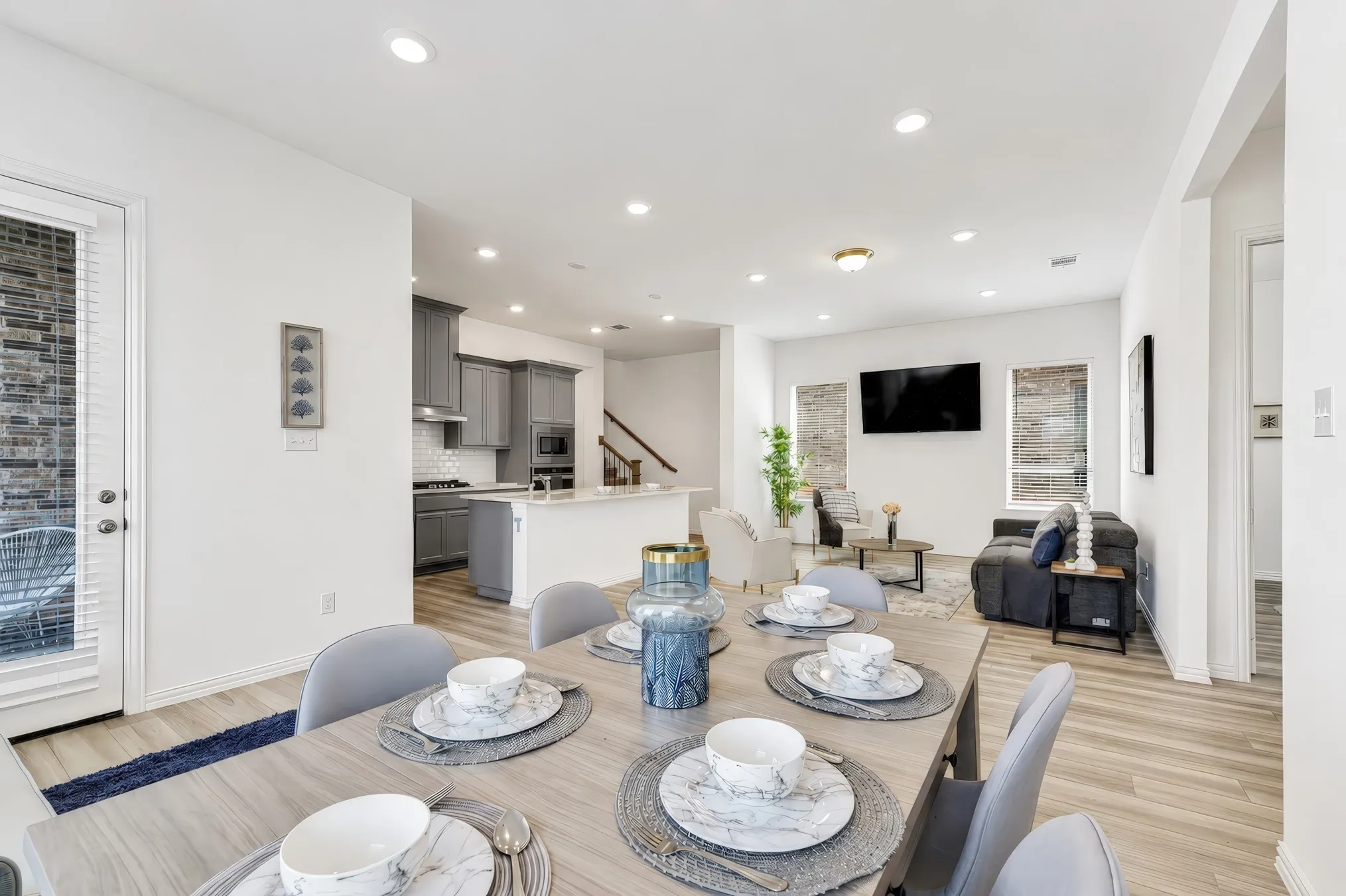 Open concept living space featuring wood-finish flooring, recessed lighting, and a white interior color palette