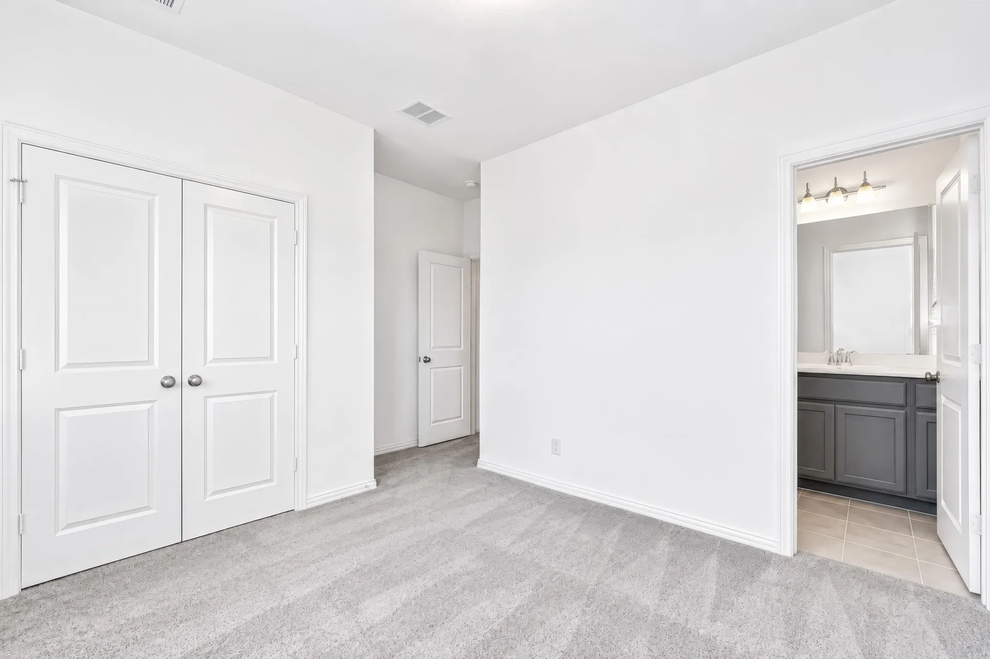 Plush carpeted flooring, white paneled doors, and ceiling-mounted lighting