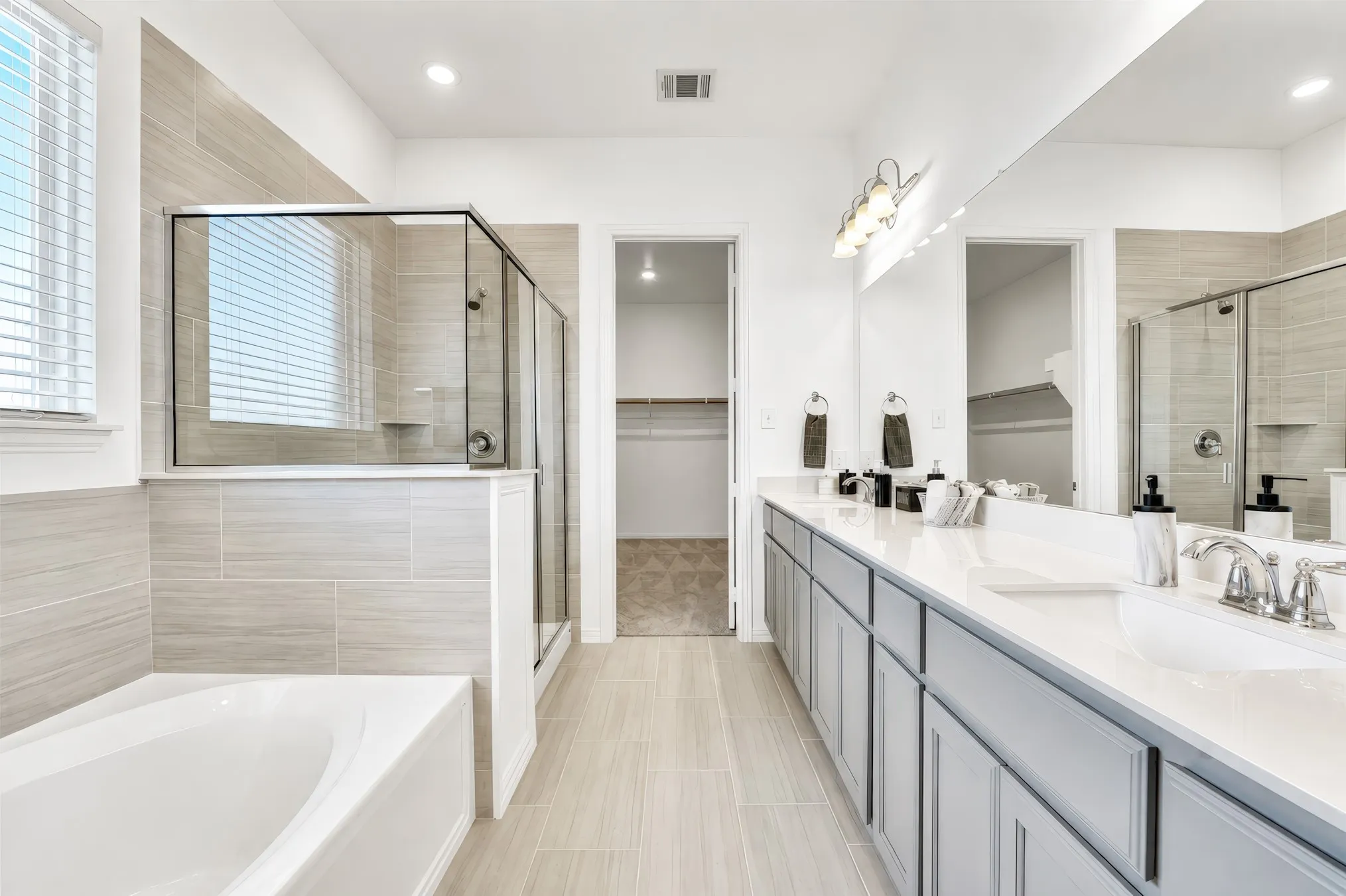 Dual vanity with undermount sinks, an expansive mirror, and chrome fixtures
