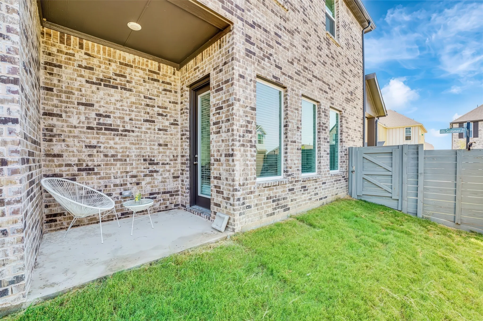 Covered patio with a concrete surface, brick exterior, and recessed lighting