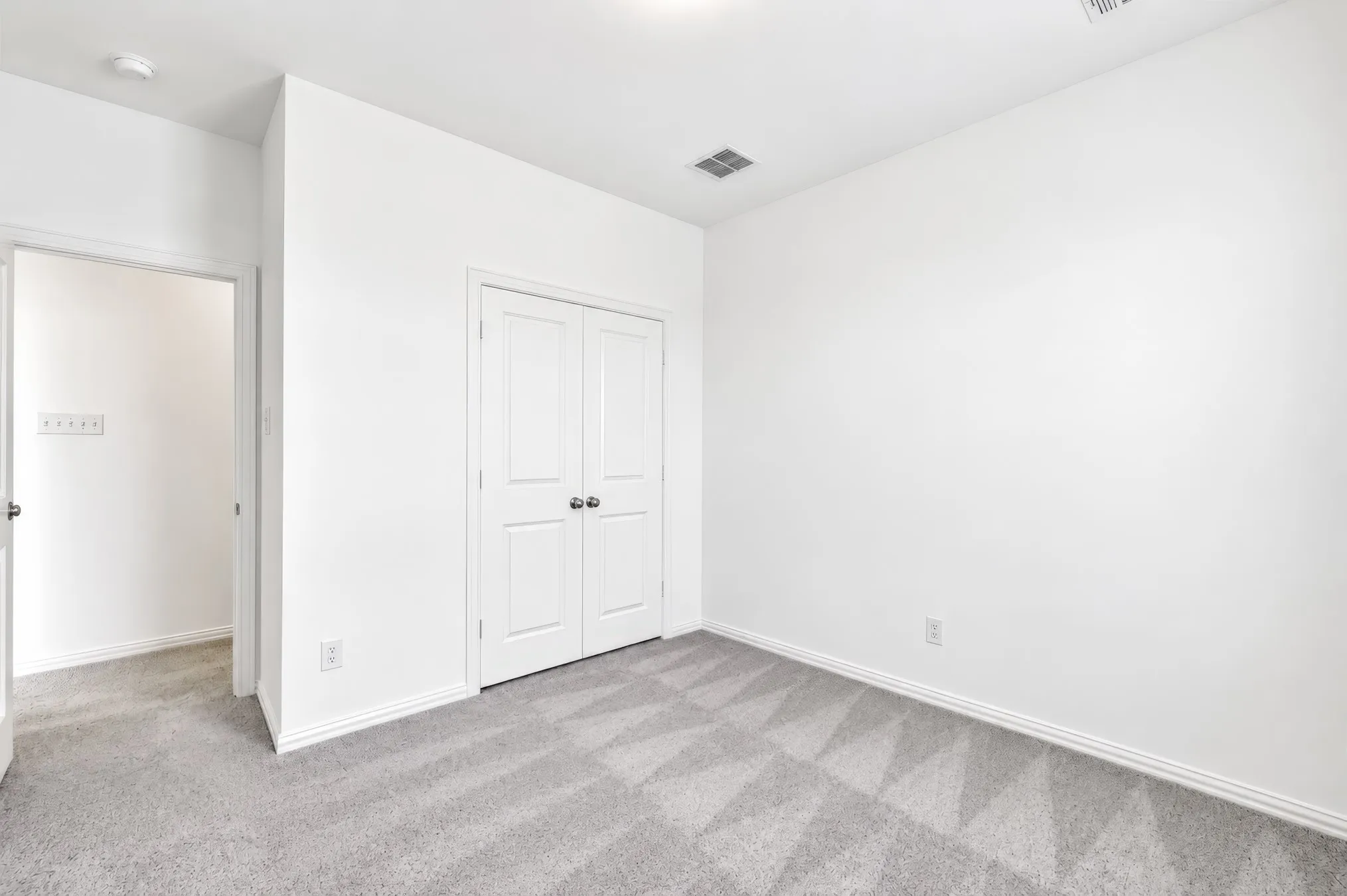 Neutral wall finishes, recessed ceiling lighting, and carpeted flooring