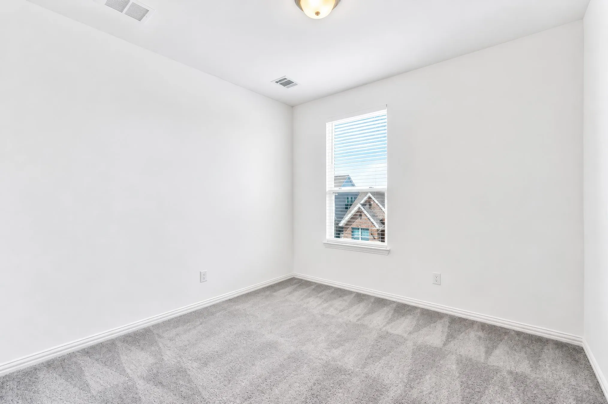 Carpeted room featuring a single window with blinds and a flush mount ceiling light