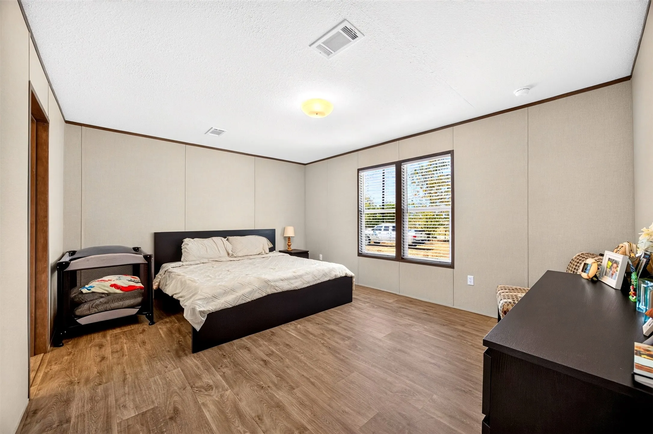 Wood-finish flooring with a neutral wall palette, a built-in window, and a ceiling-mounted light fixture