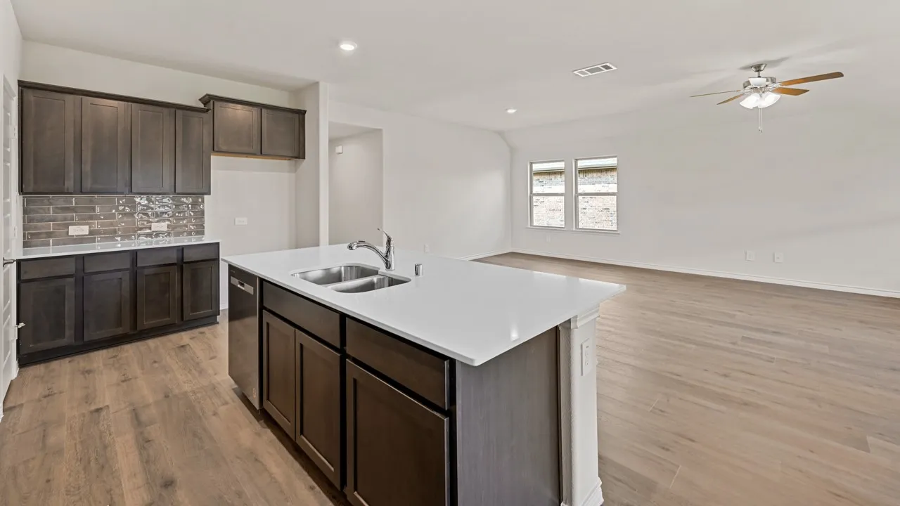 Spacious open-concept living area featuring wood-finish flooring, recessed lighting, and a ceiling fan