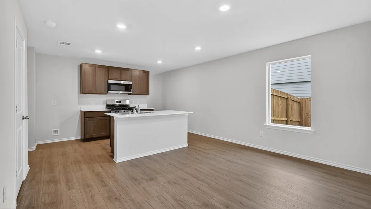 Open-concept layout with wood-finish flooring, recessed lighting, and a kitchen island