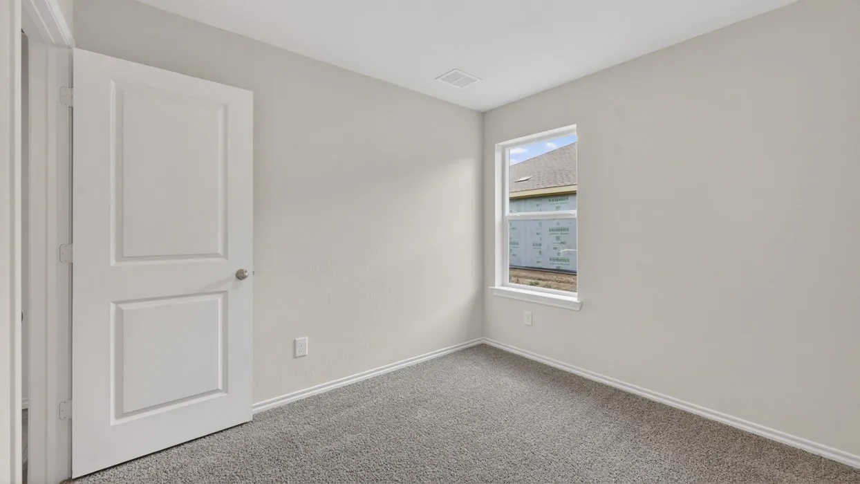Neutral wall paint, gray carpeting, a two-panel interior door, and a single-pane window