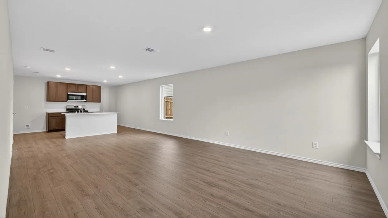 Open-concept living space featuring wood-finish flooring, recessed lighting, and a kitchen island with a white countertop