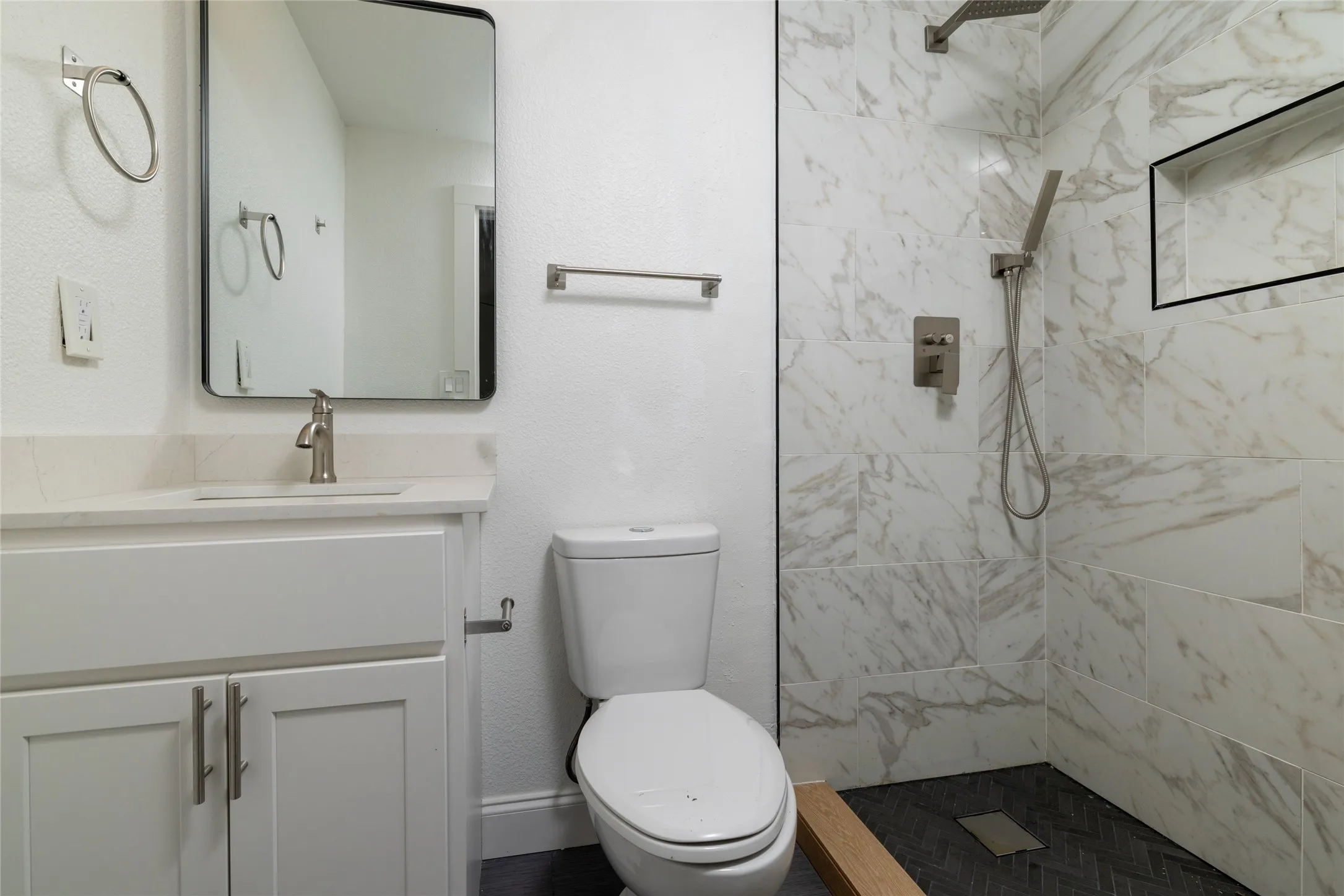 White shaker vanity with brushed nickel hardware, undermount sink, and light countertop