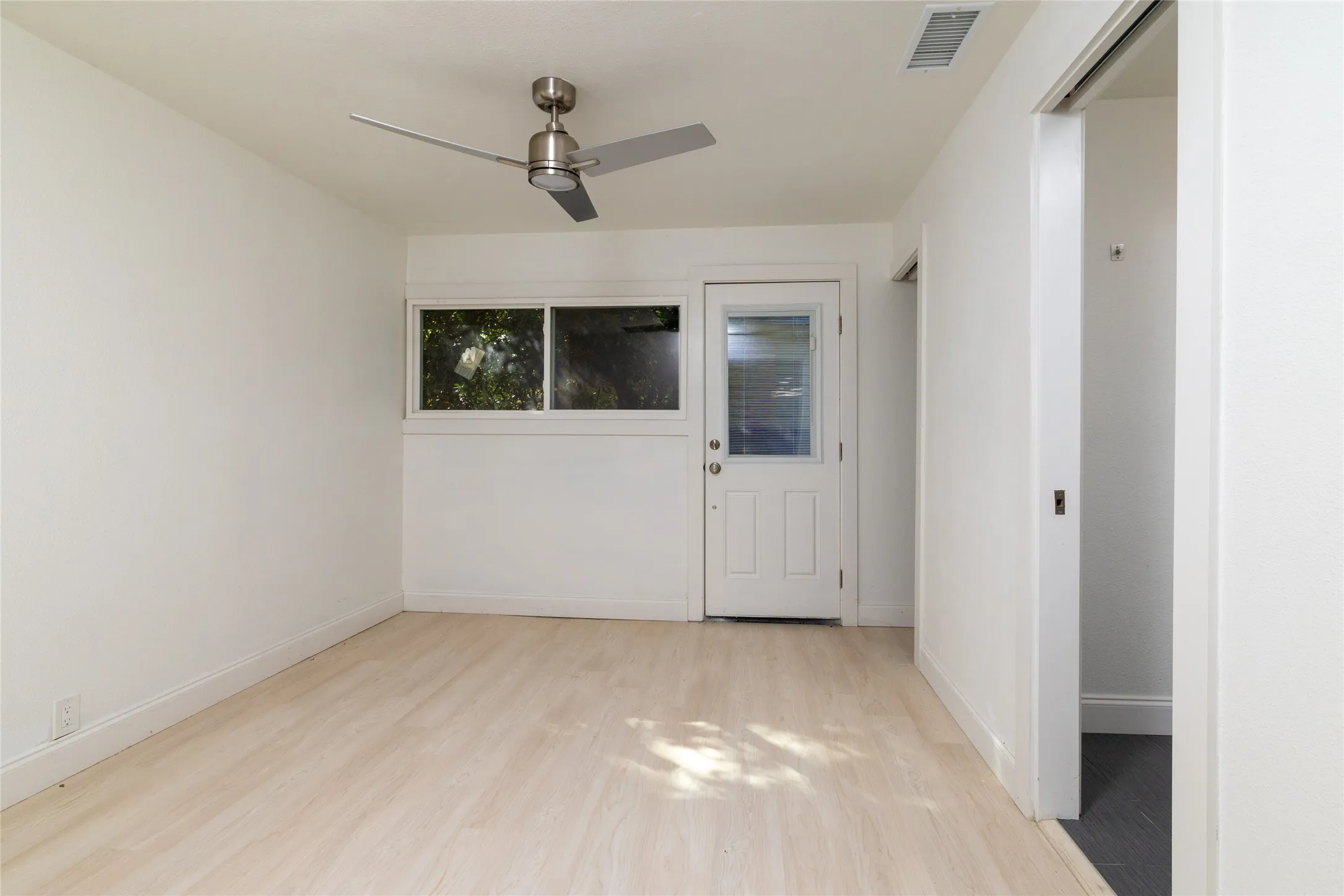 Light wood-finish flooring with white walls