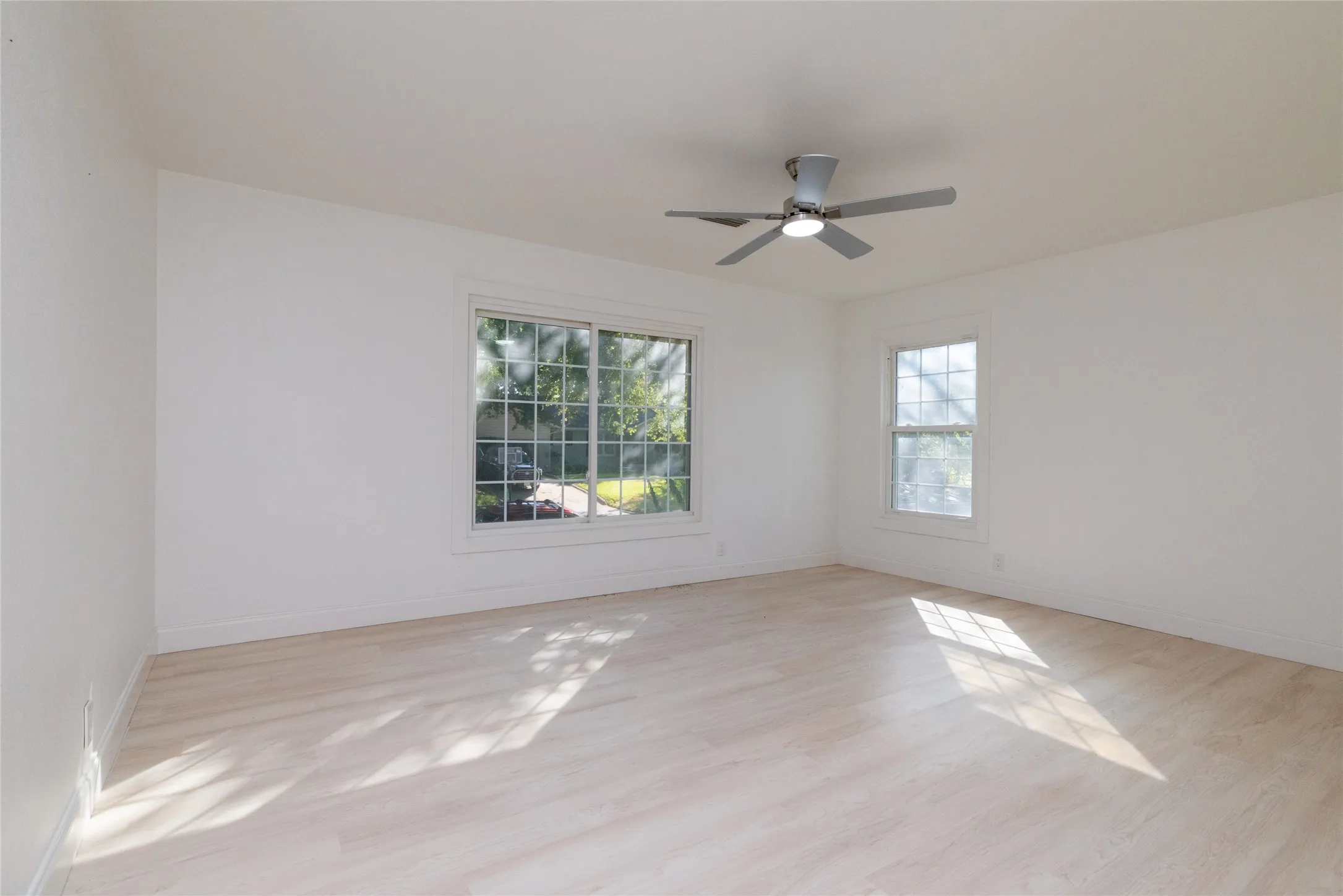 Light wood-finish flooring with white walls and trim