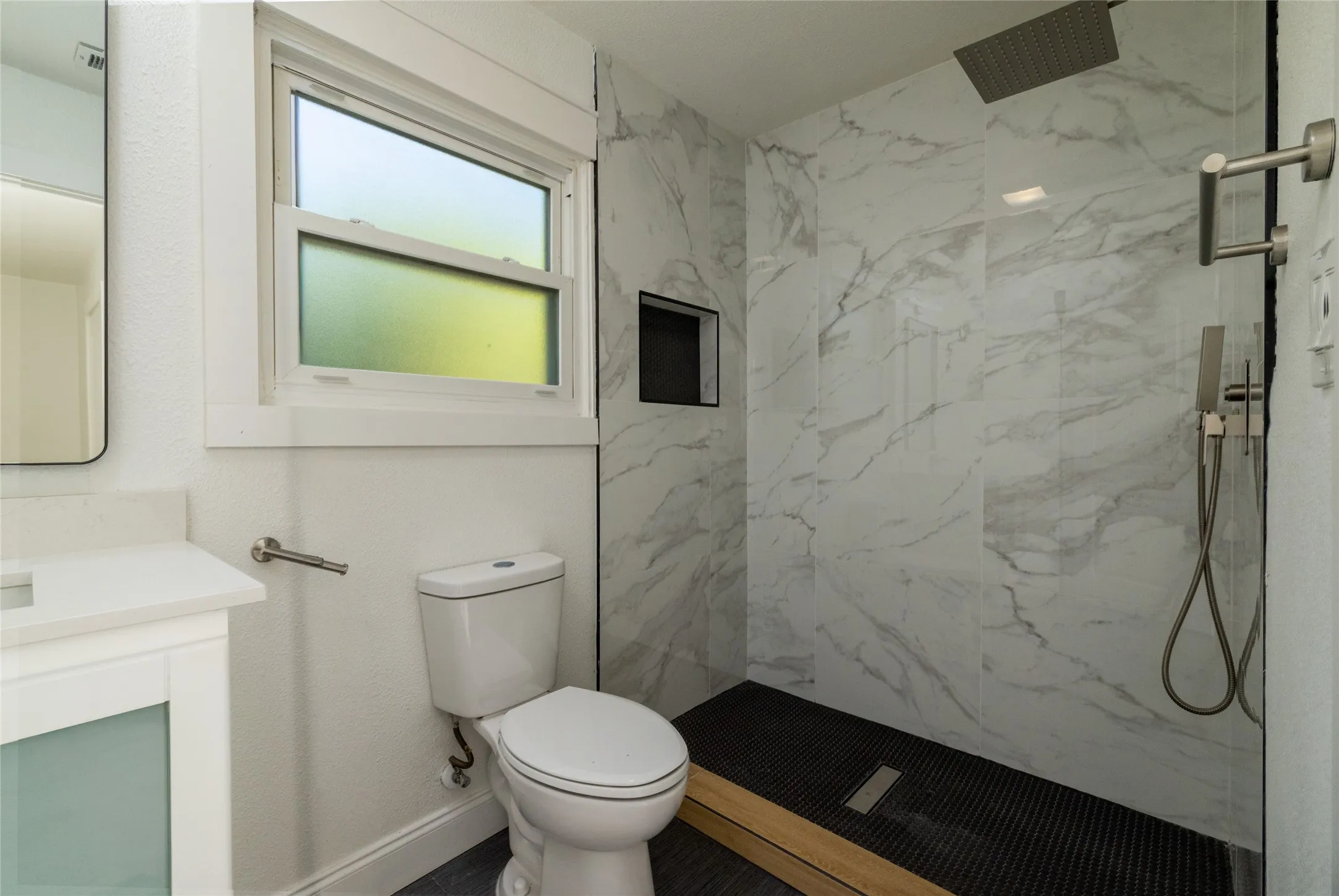 Walk-in shower with large format wall tile and integrated niche