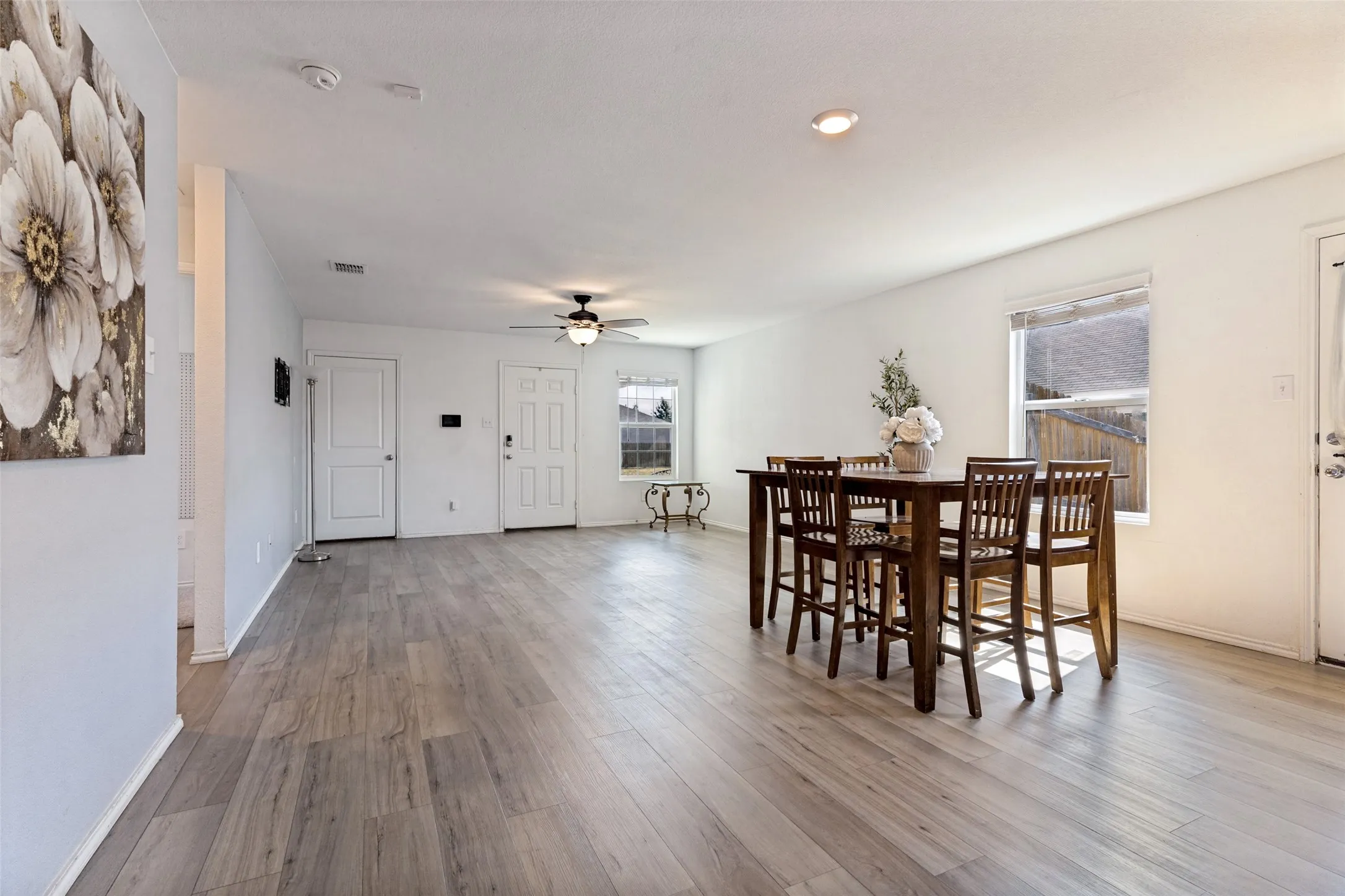 Open-concept living area with wood-finish flooring, recessed lighting, and a ceiling fan