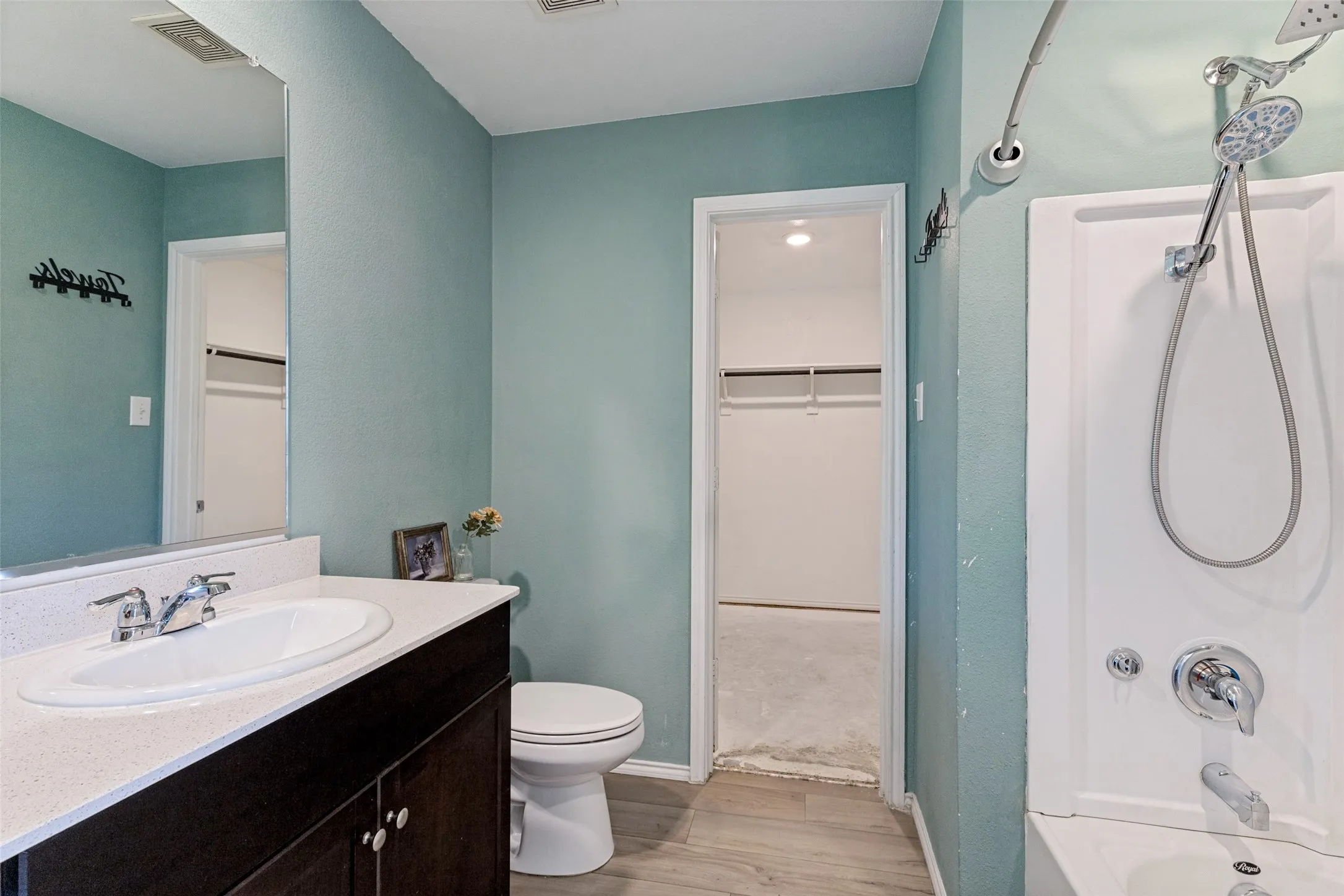 Primary bath, vanity with integrated sink, chrome faucet, and dark wood-finish cabinetry