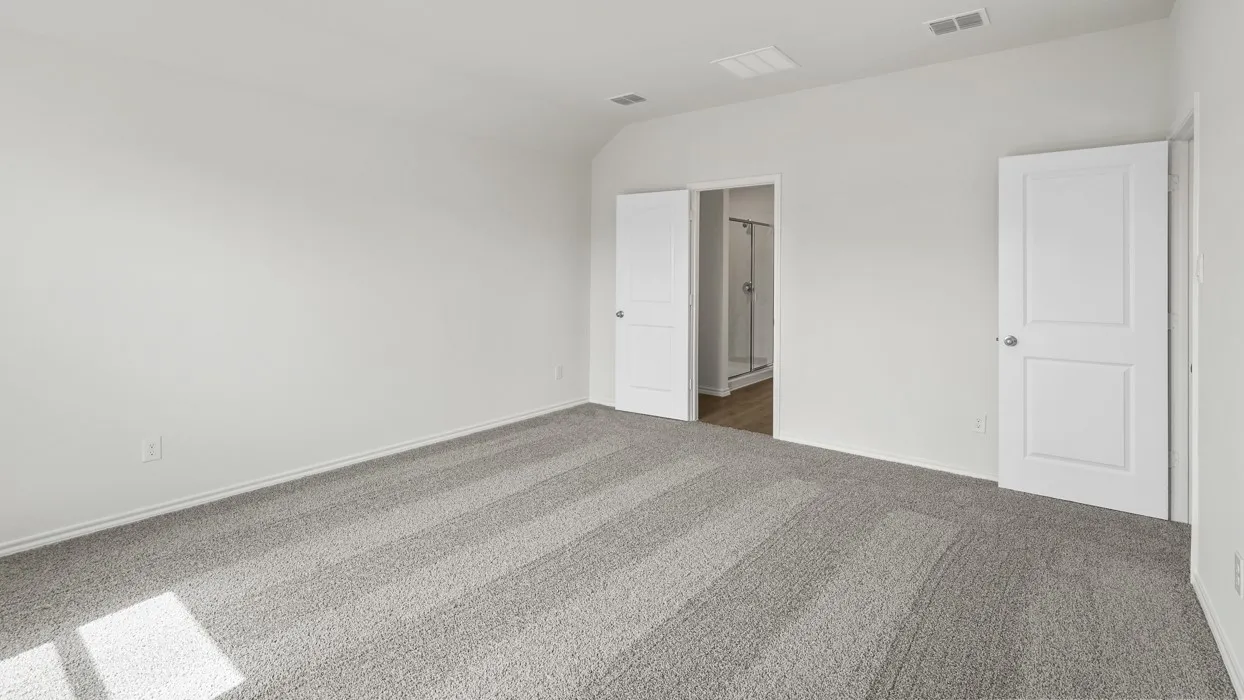 Spacious room featuring light gray carpeting, crisp white walls, and two white panel doors