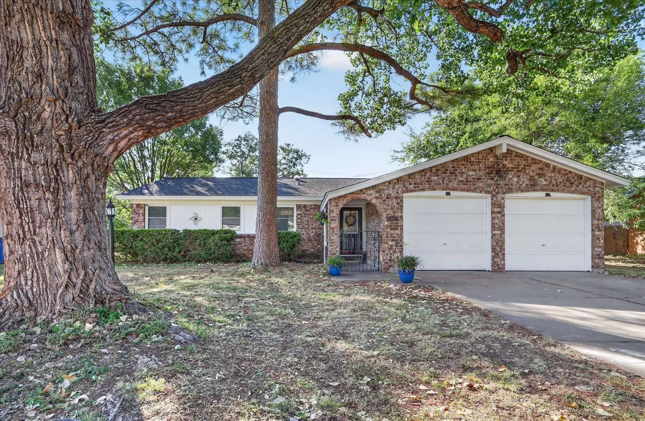 Brick exterior with white trim, a covered entryway, and a two-car garage