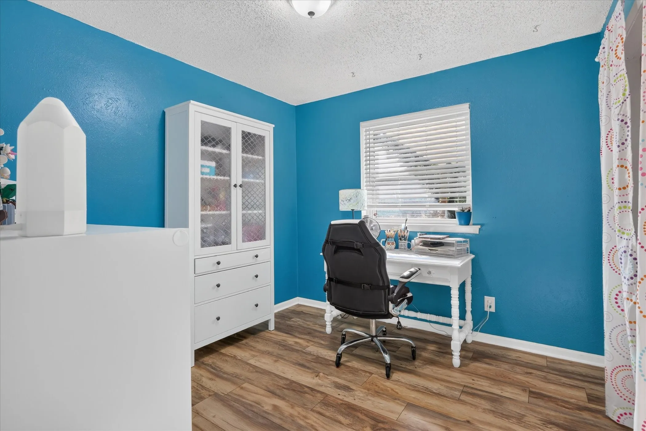 Wood-finish flooring, single window with blinds, and recessed lighting