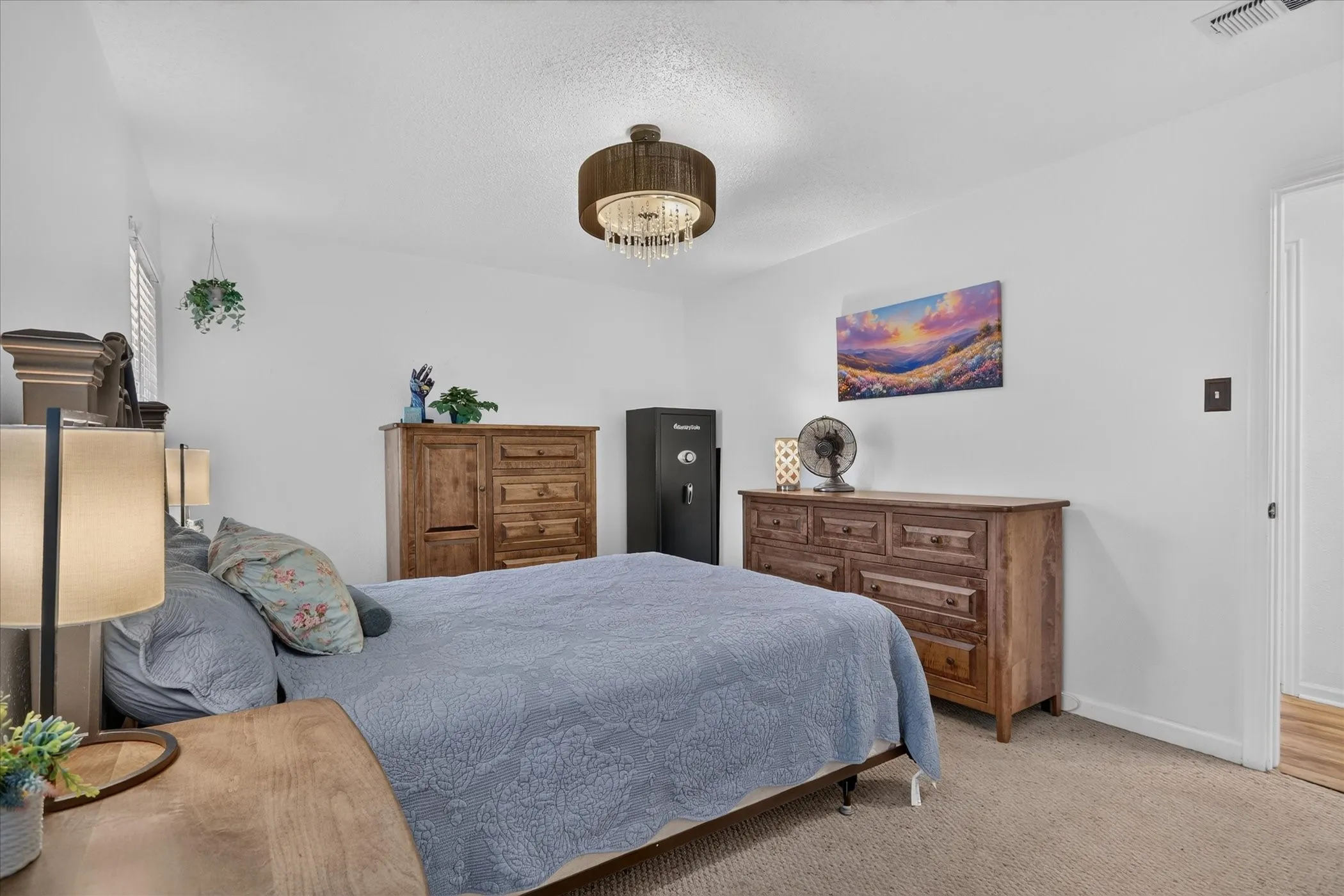 Carpeted flooring, white walls, and a decorative ceiling light fixture