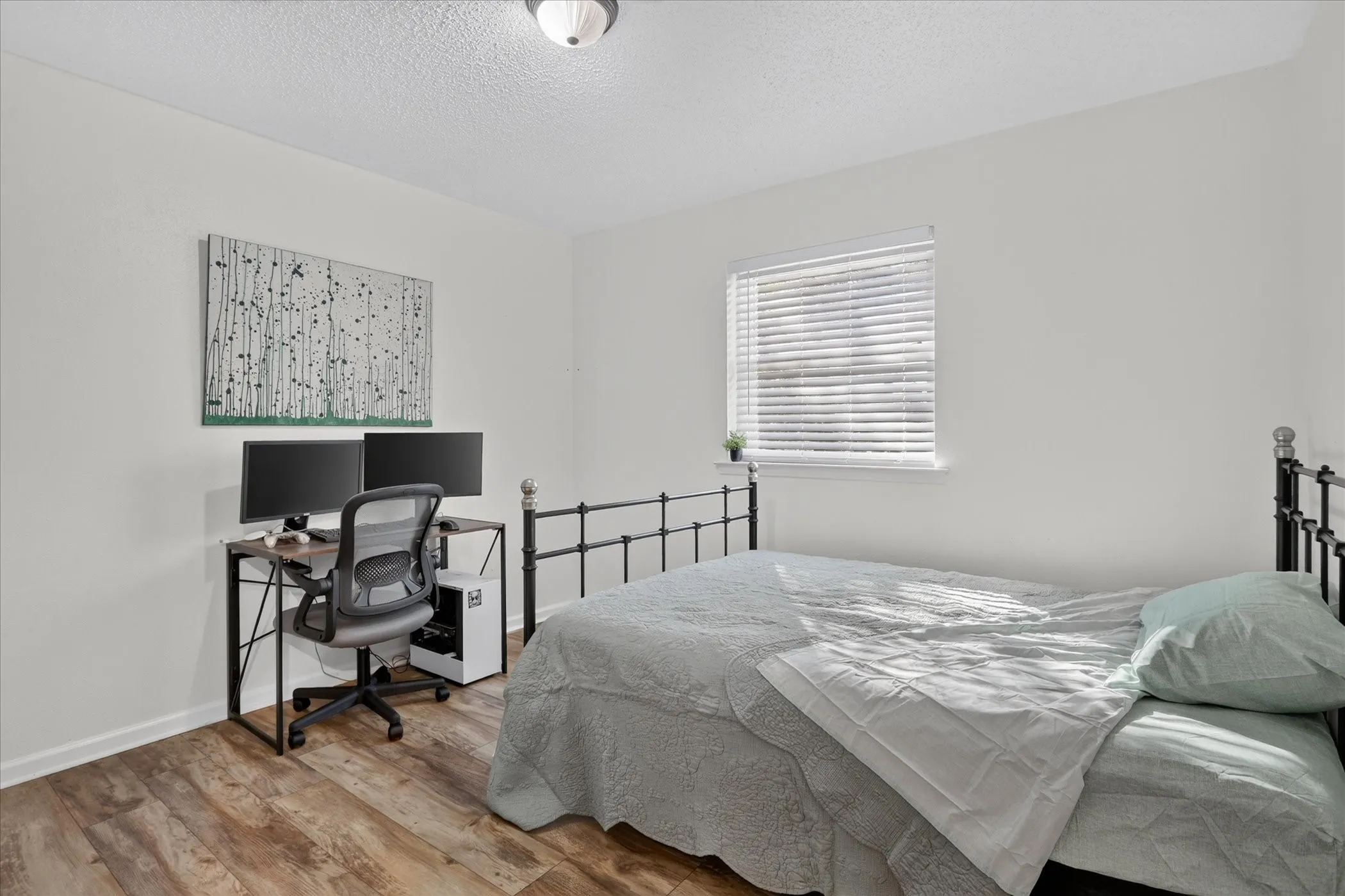 Wood-finish flooring with white walls and a ceiling-mounted light fixture
