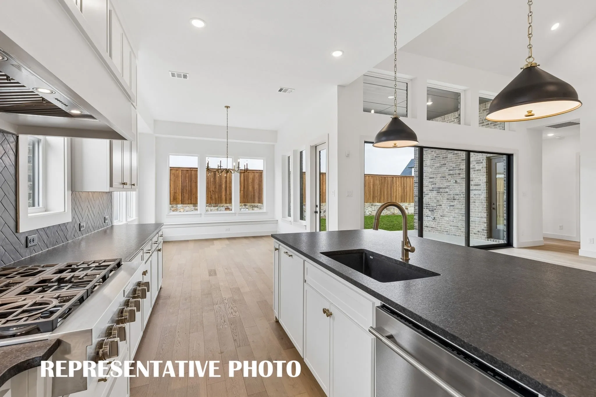 Gorgeous cabinetry, beautiful counter tops and designer backsplash pair effortlessly with contemporary stainless steel to create a kitchen for the ages!  REPRESENTATIVE PHOTO