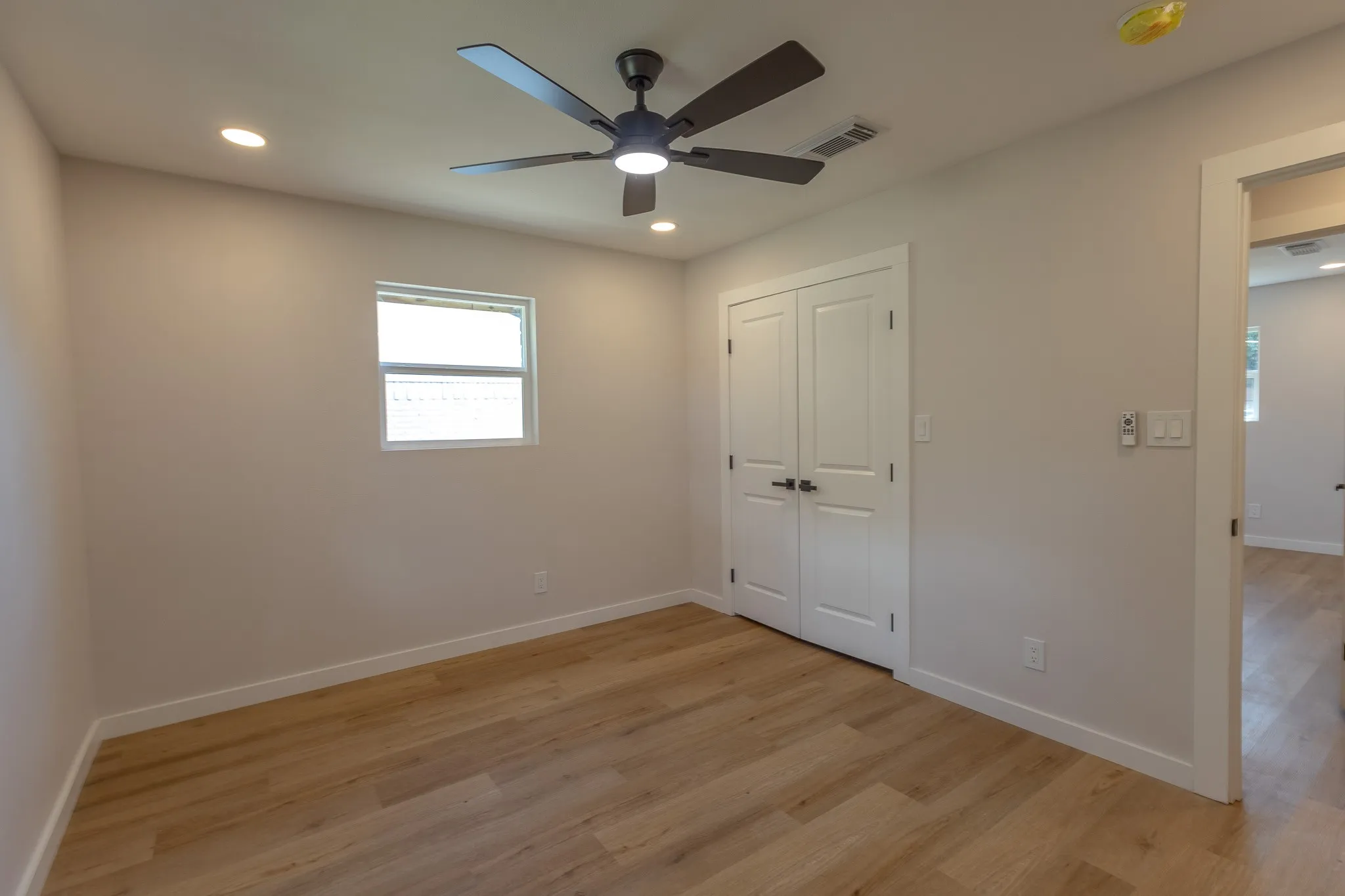 Wood-finish flooring, recessed lighting, and a ceiling fan with integrated light fixture