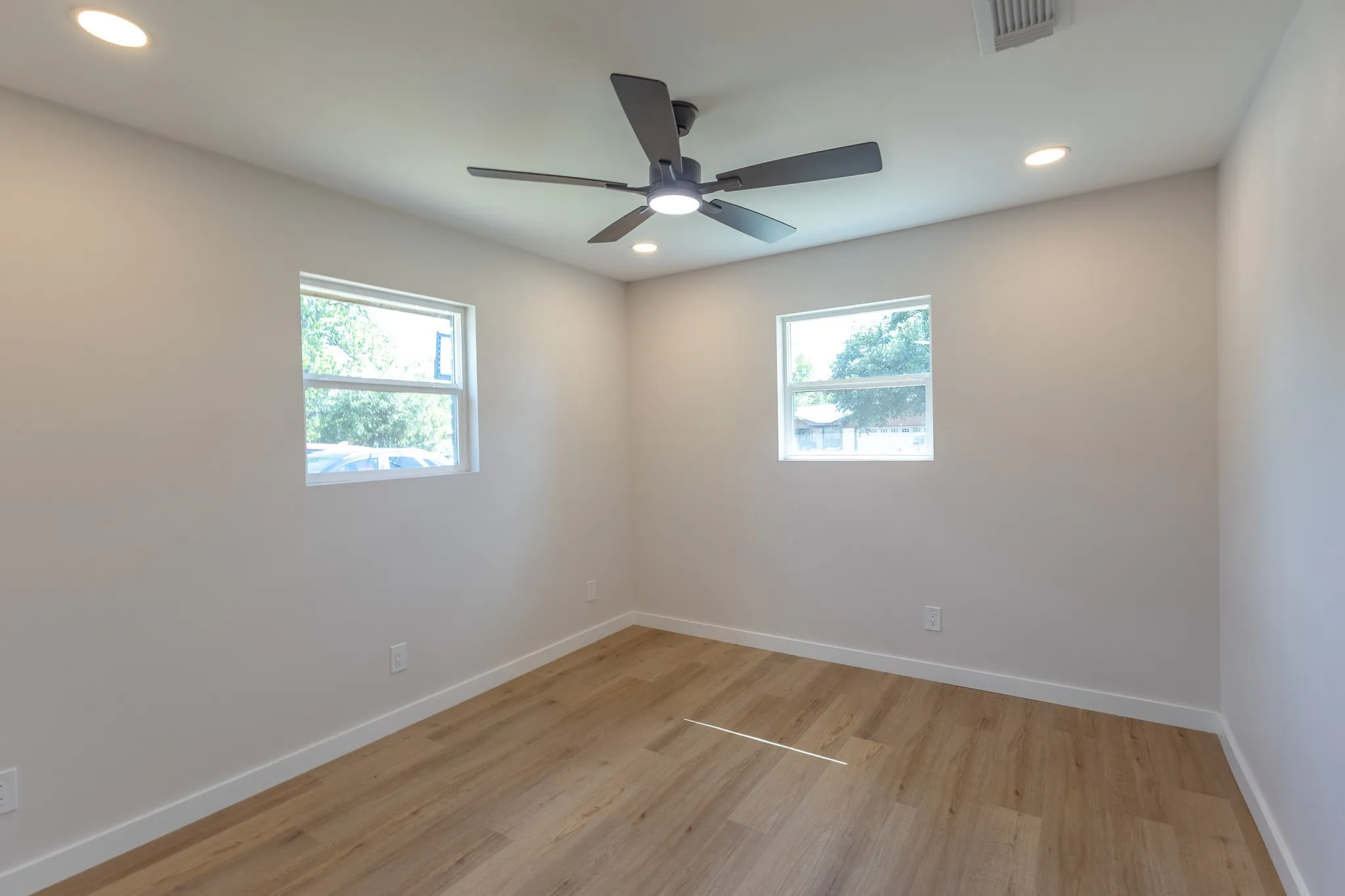 Wood-finish flooring, recessed lighting, and a ceiling fan with integrated lighting