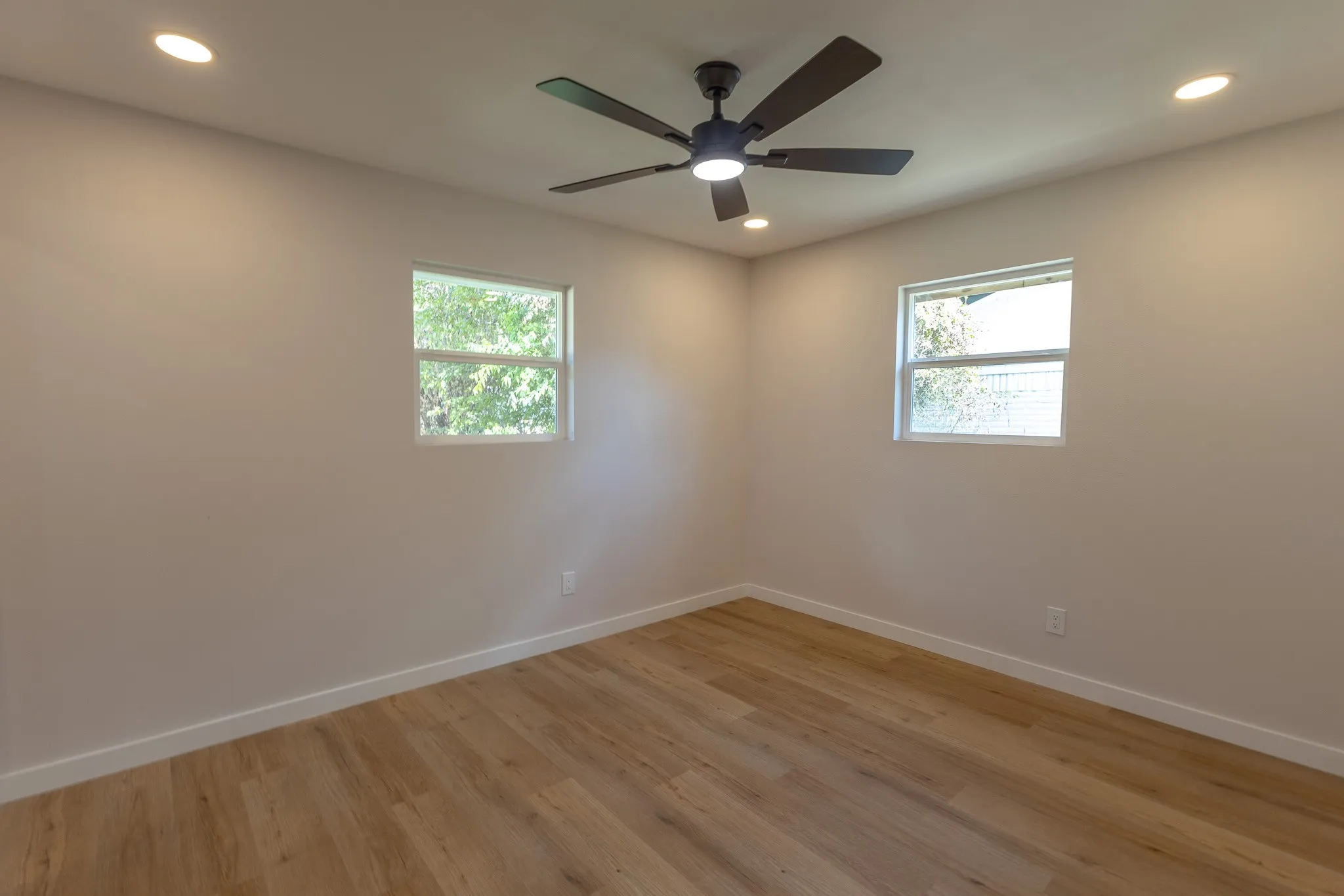 Recessed lighting, wood-finish flooring, and a ceiling fan with integrated lighting