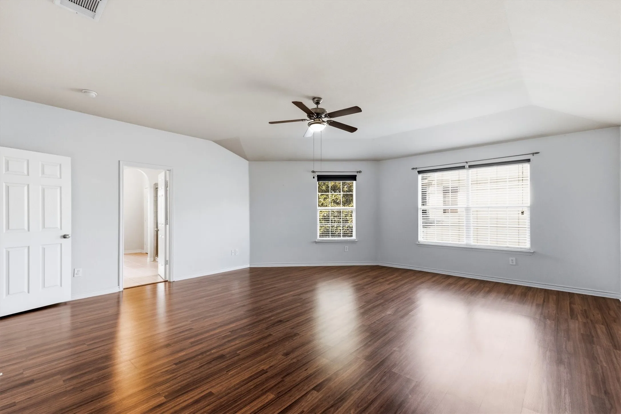Second floor primary bedroom with a second walk-in closet and natural lighting. With a celing fan.
