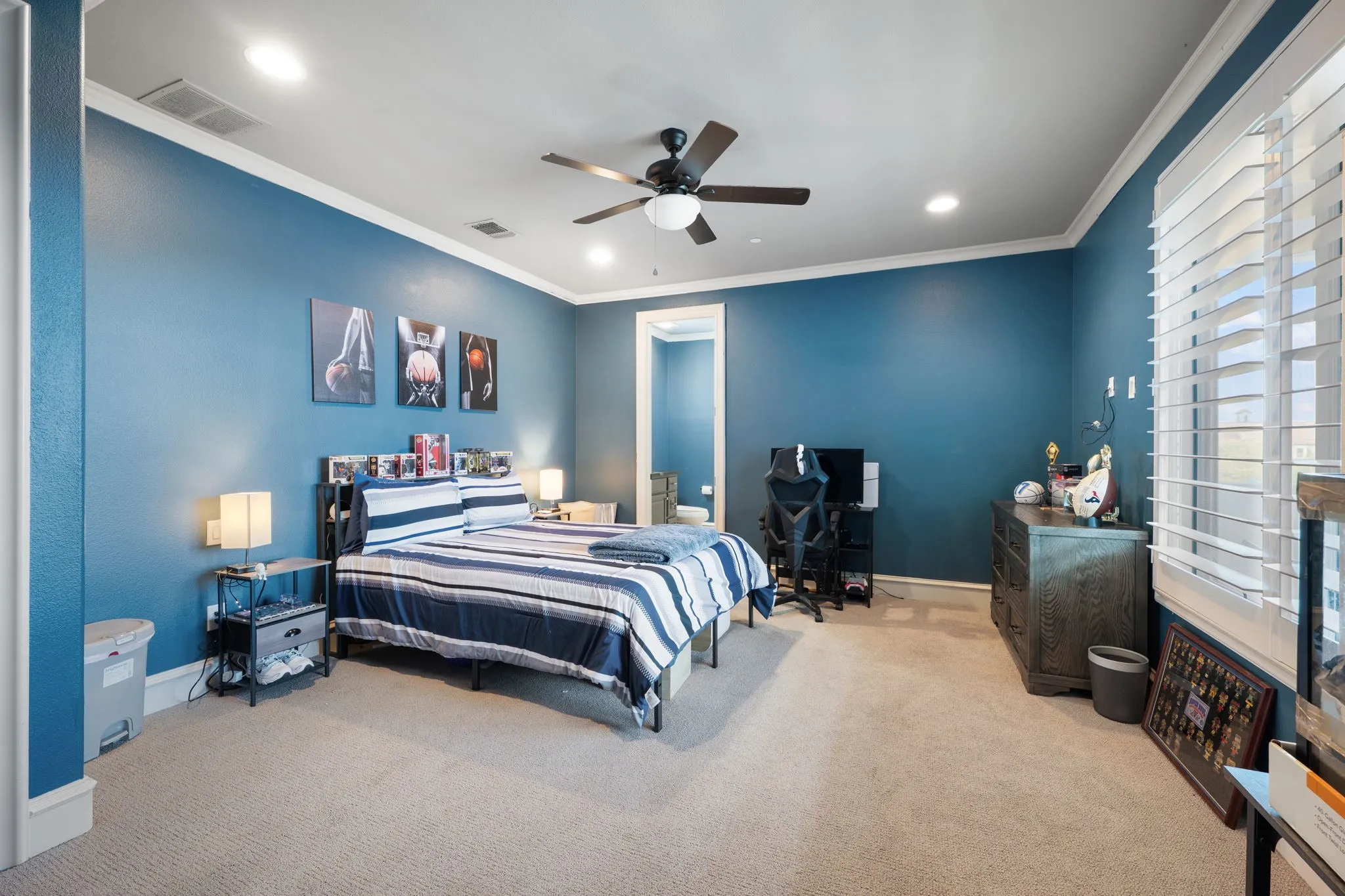 Carpeted flooring, crown molding, ceiling fan, recessed lighting, and window with plantation shutters
