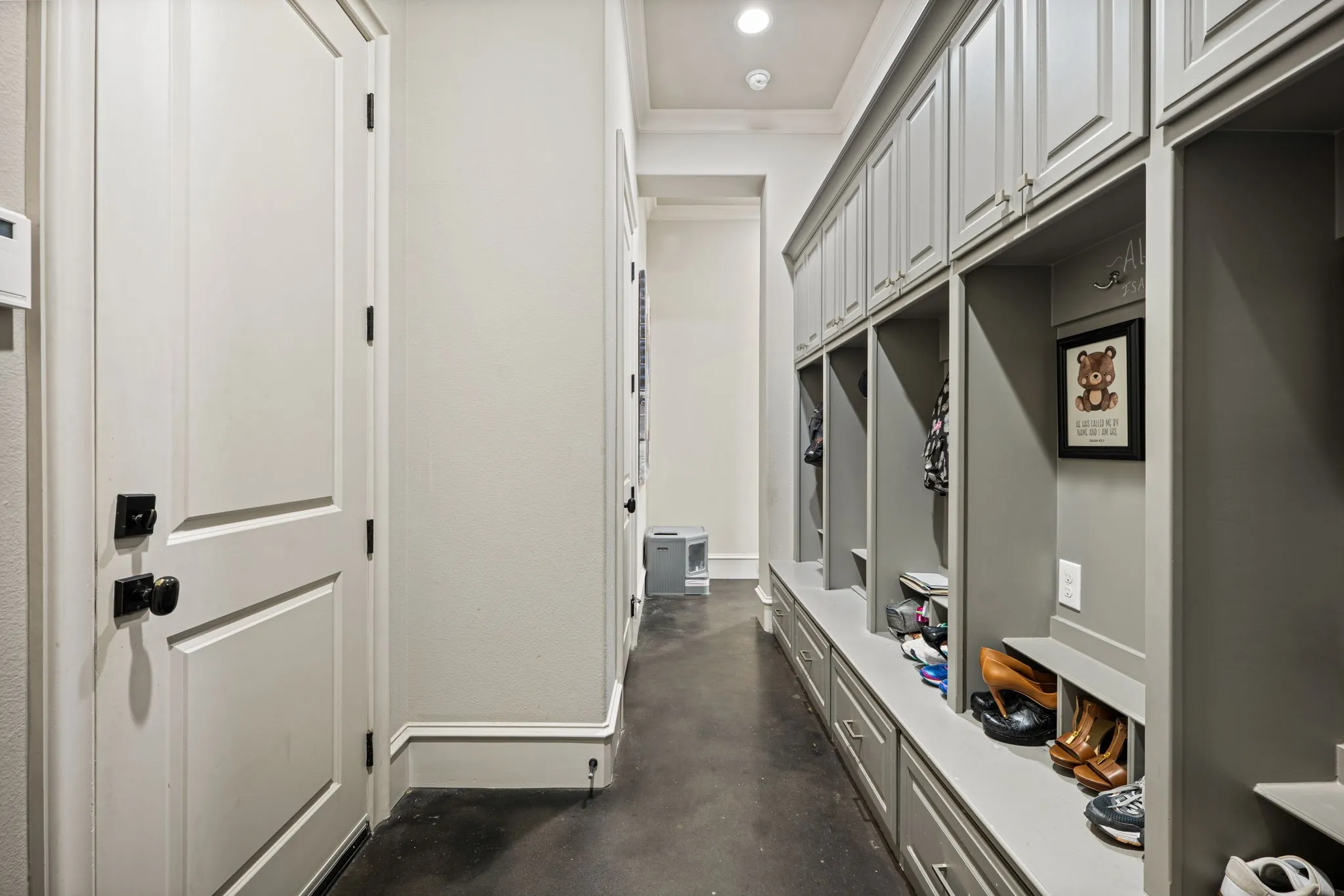 Hallway featuring built-in gray cabinetry with upper storage, open cubbies, and lower drawers