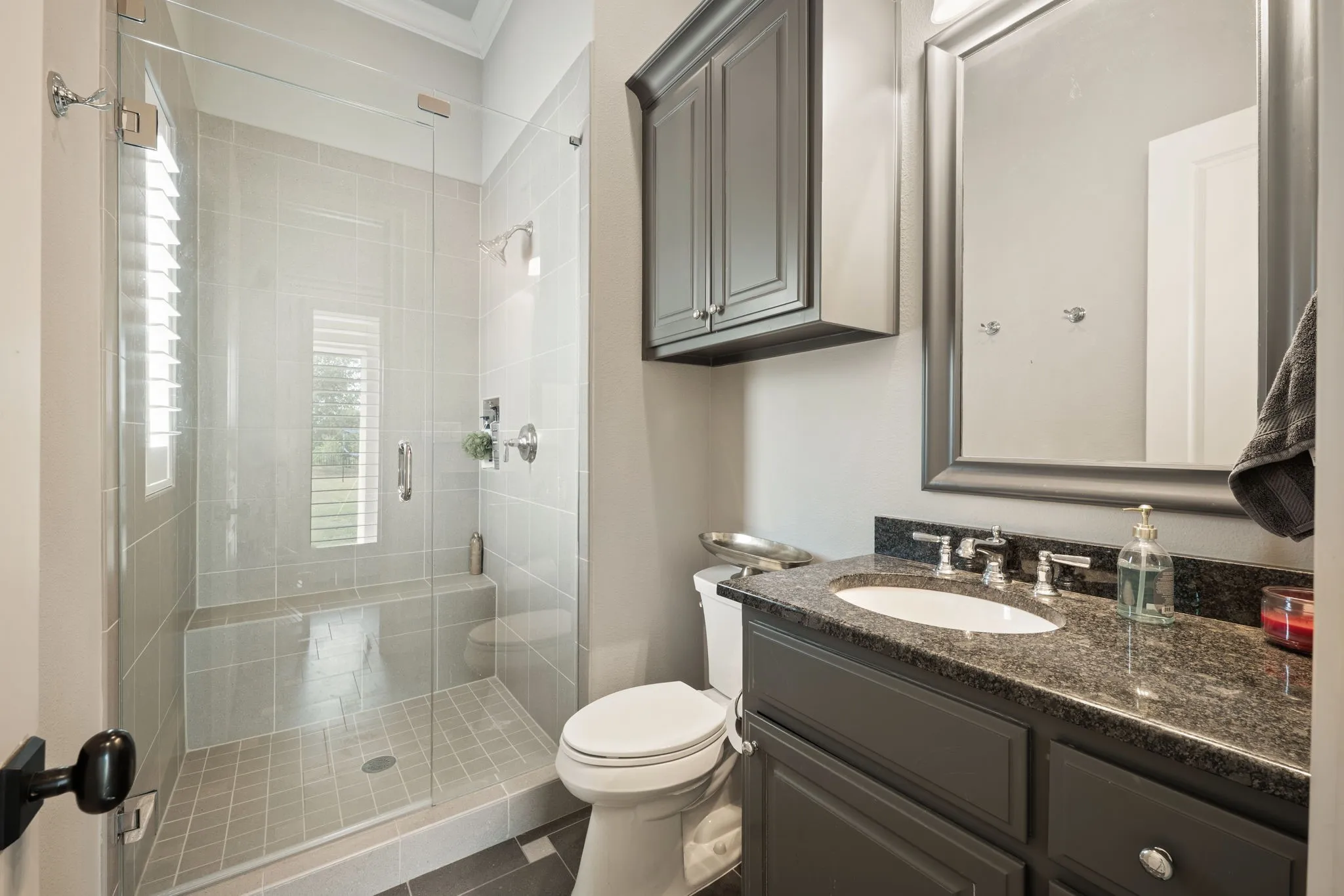 Glass-enclosed shower with tile surround and built-in bench