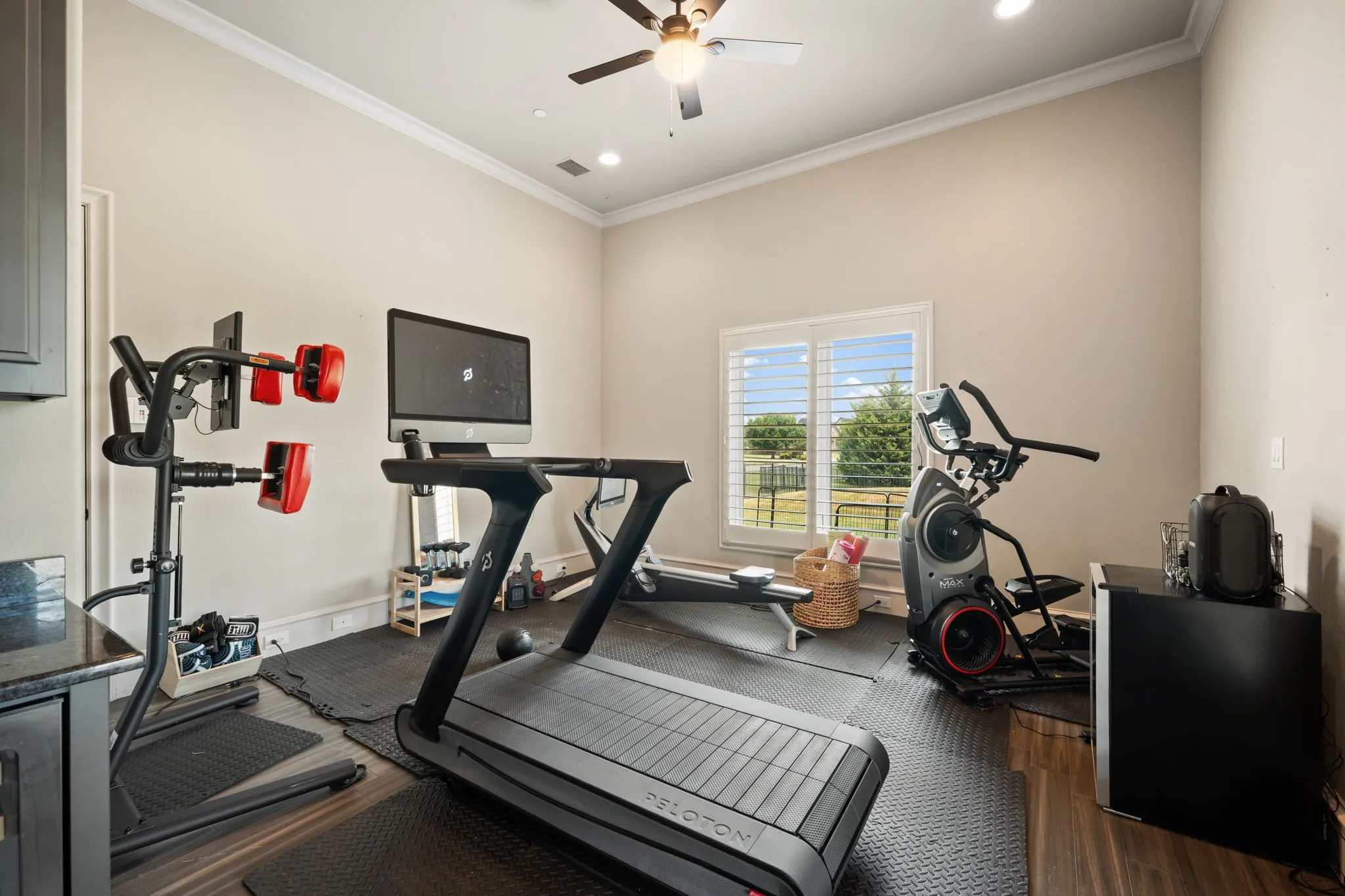Recessed lighting, ceiling fan, crown molding, wood-finish flooring, and a window with plantation shutters