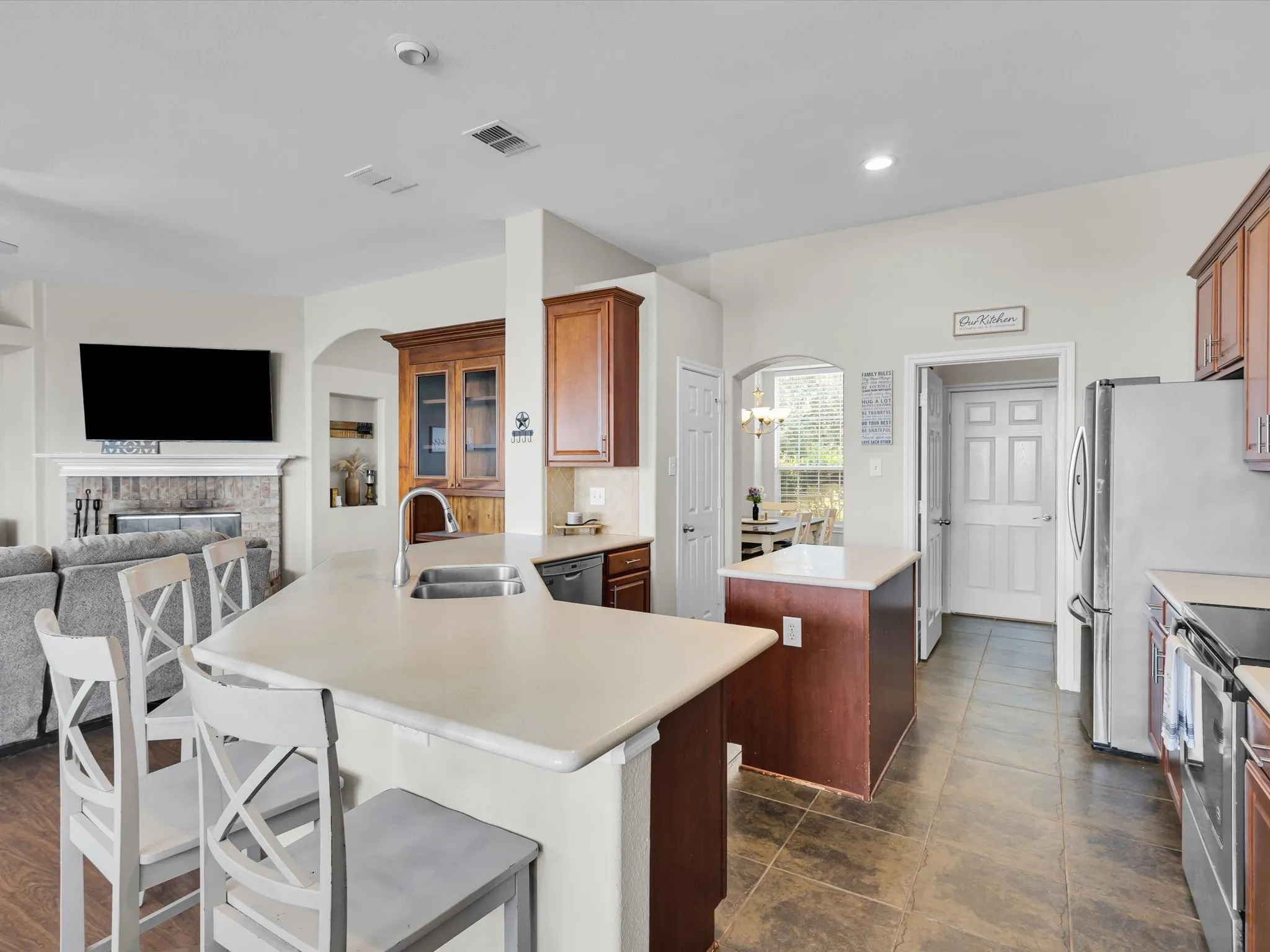 Kitchen featuring a built-in stainless steel double sink, a separate kitchen island, and wood-finish cabinetry