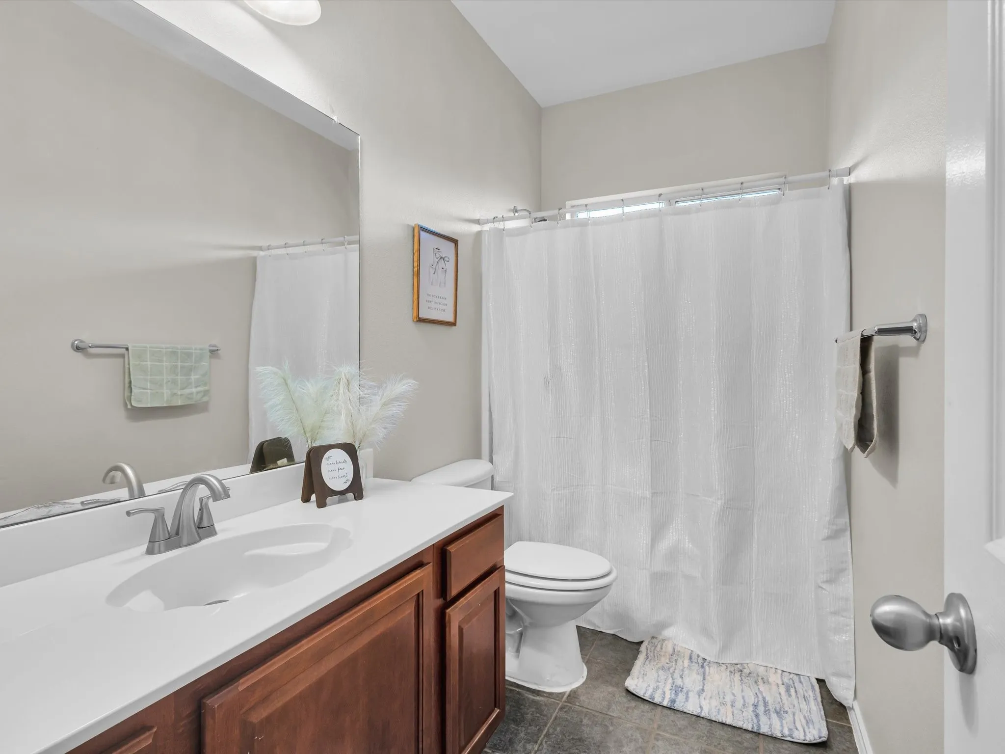Single vanity with a white countertop and dark wood-finish cabinetry