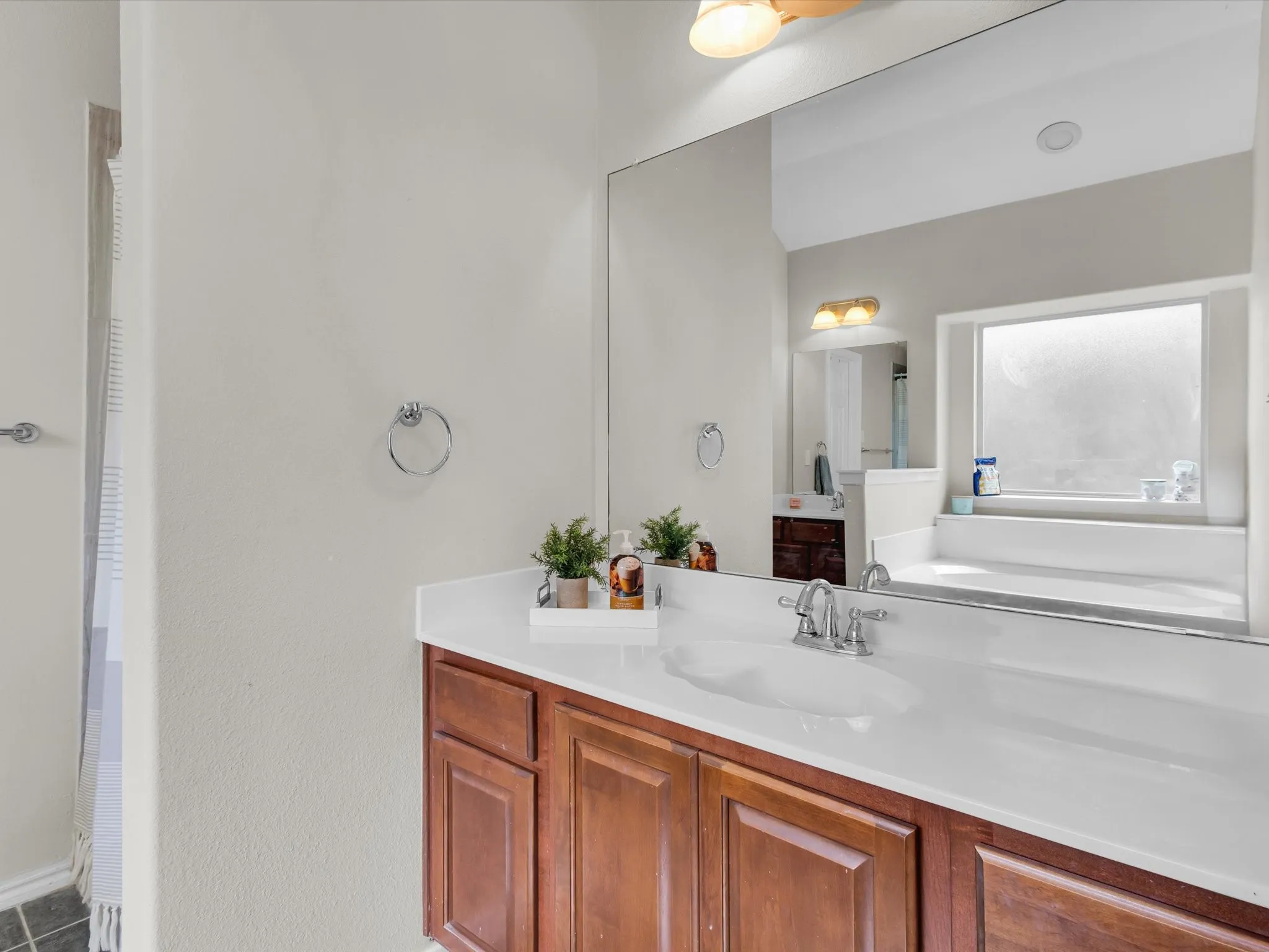 Integrated vanity with a single basin sink, chrome faucet, and wood-finish cabinetry