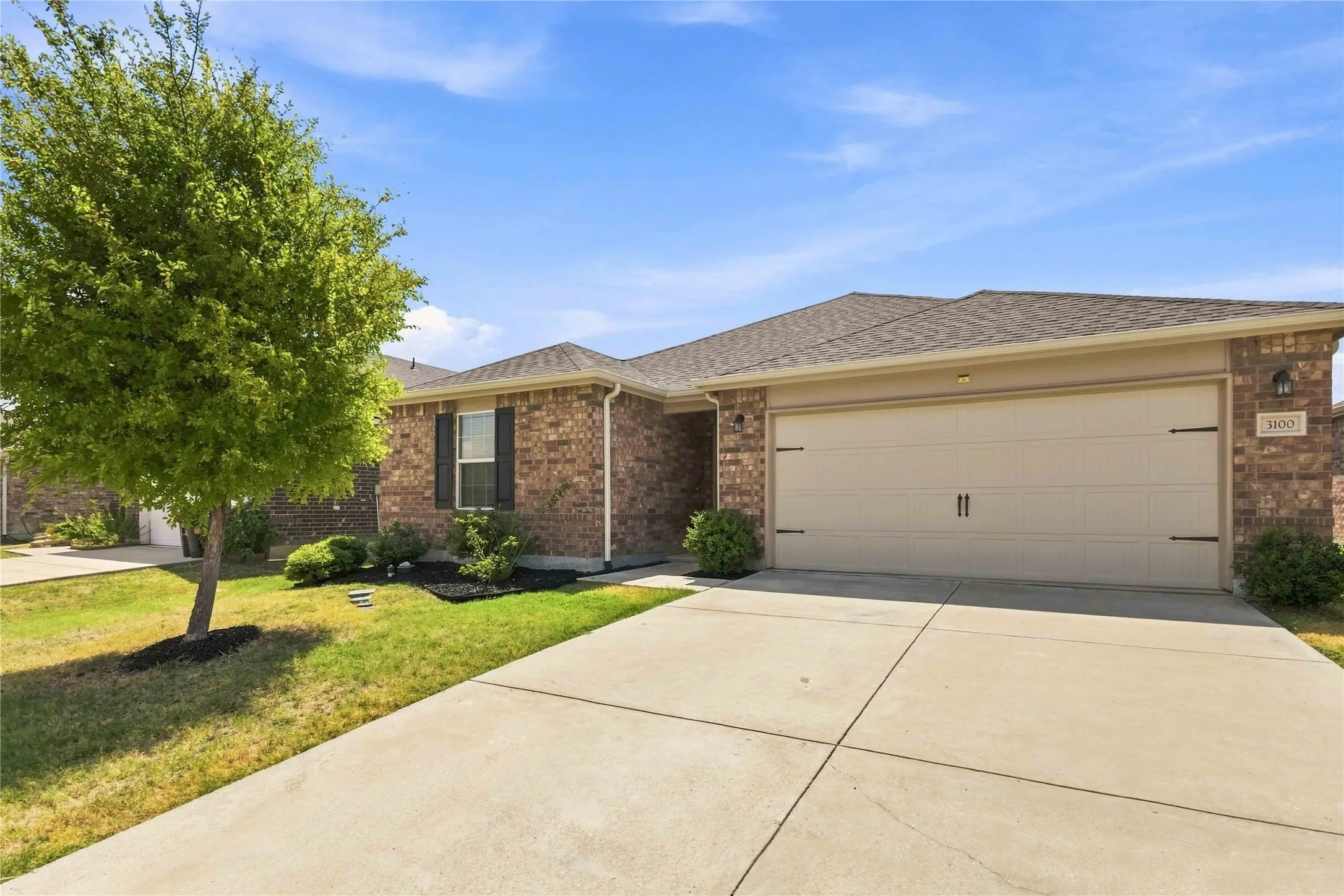 Brick exterior with a gabled roof and attached two-car garage