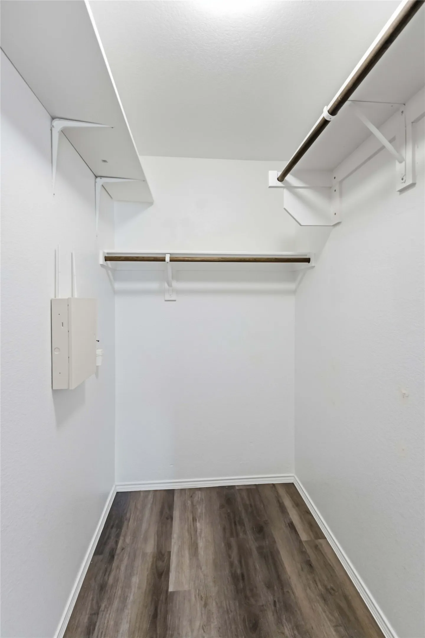 Built-in shelving, hanging rods, and wood-finish flooring