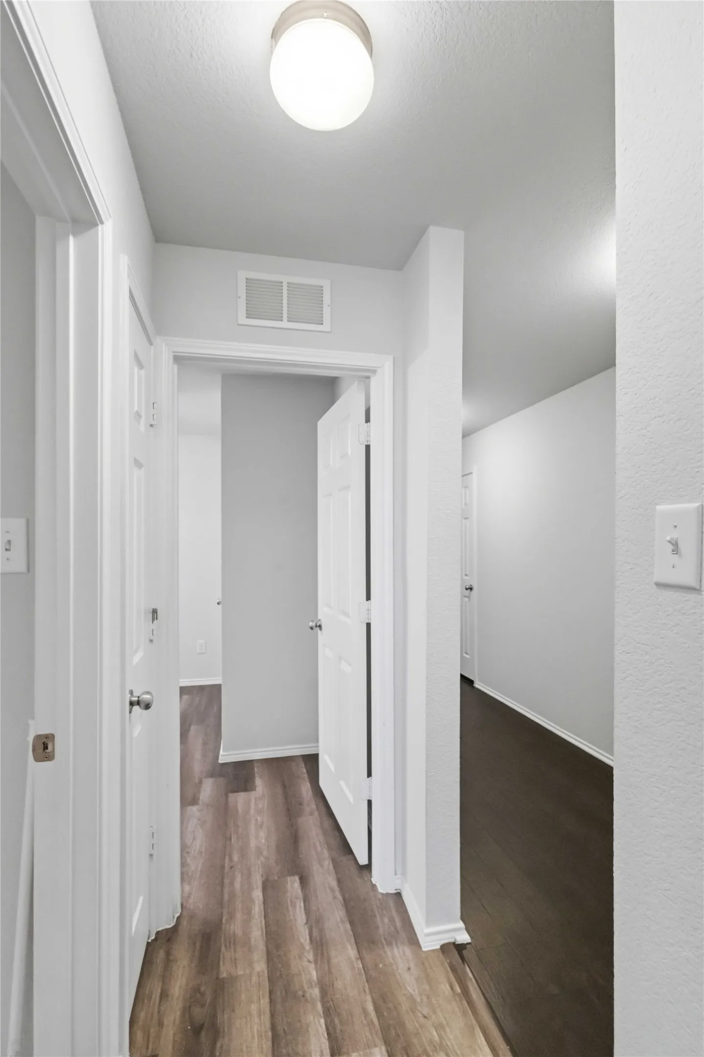 Wood-finish flooring throughout, white interior doors, and neutral wall tones