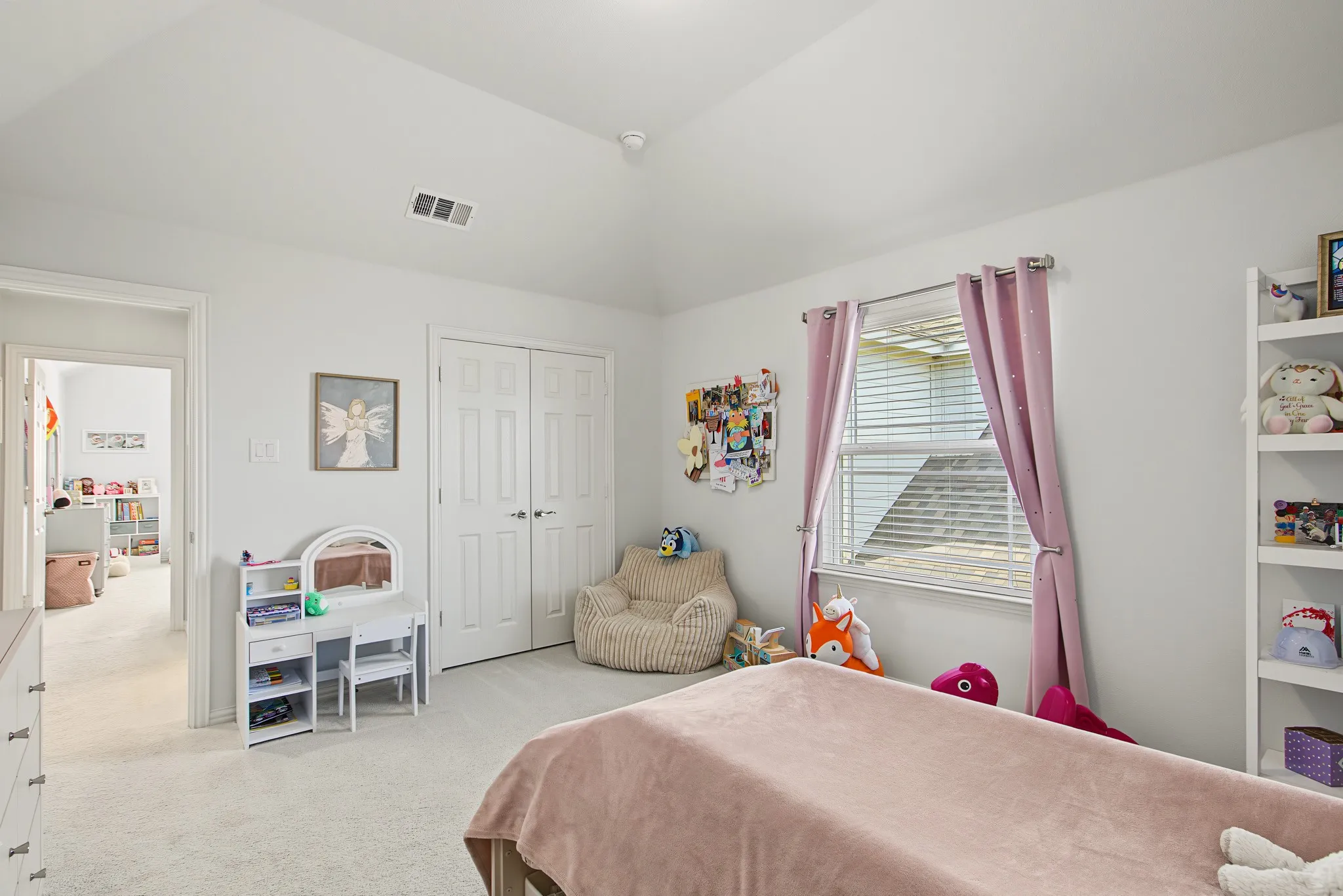 Vaulted ceiling, plush carpet flooring, paneled interior doors, and a double-hung window