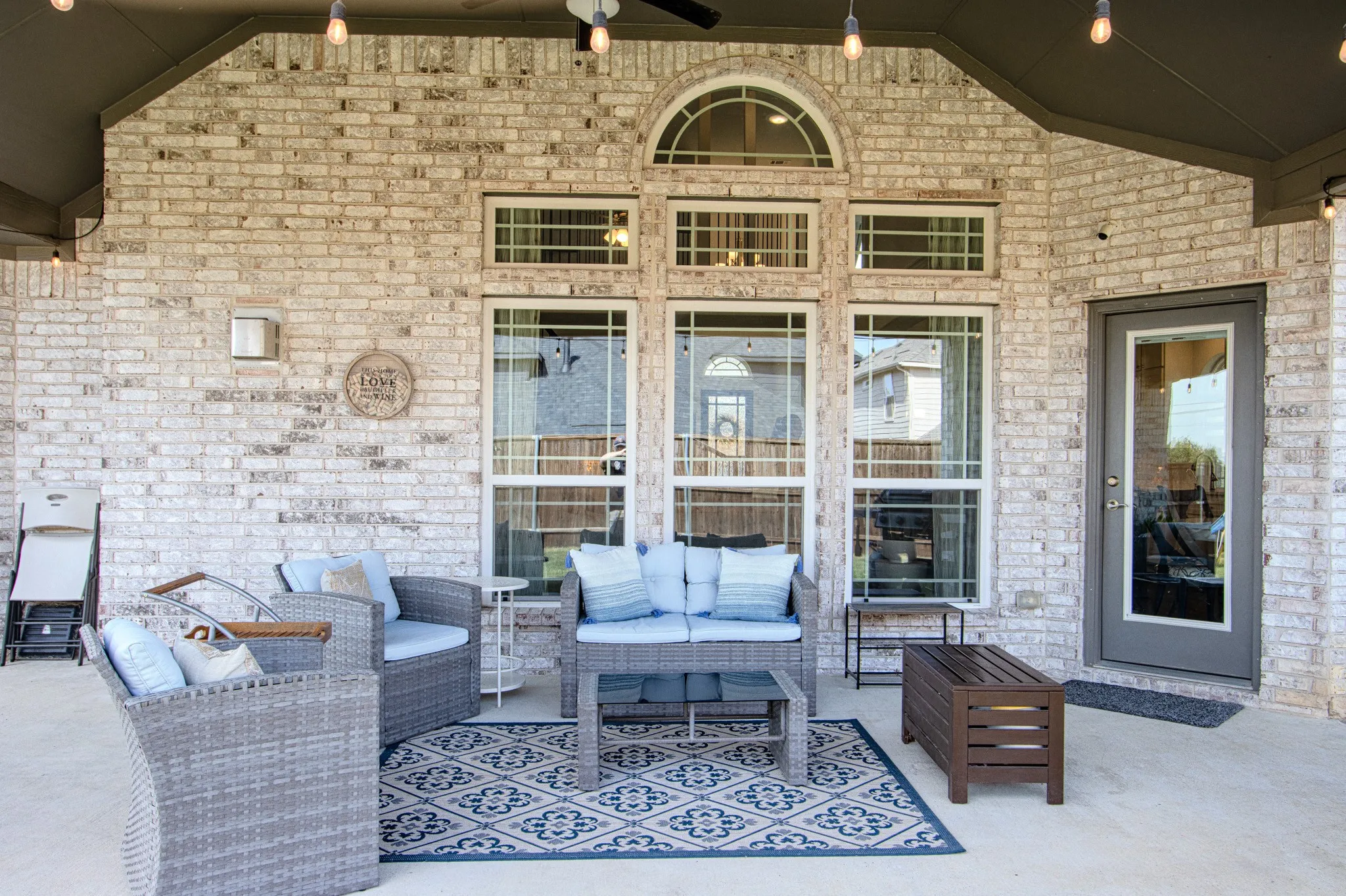 Covered patio with brick exterior, arched transom window, and exterior door with glass insert