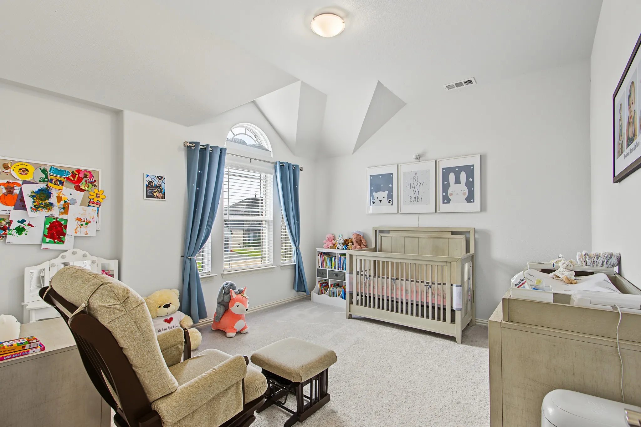 Vaulted ceiling with an arched window, featuring carpet flooring and recessed lighting