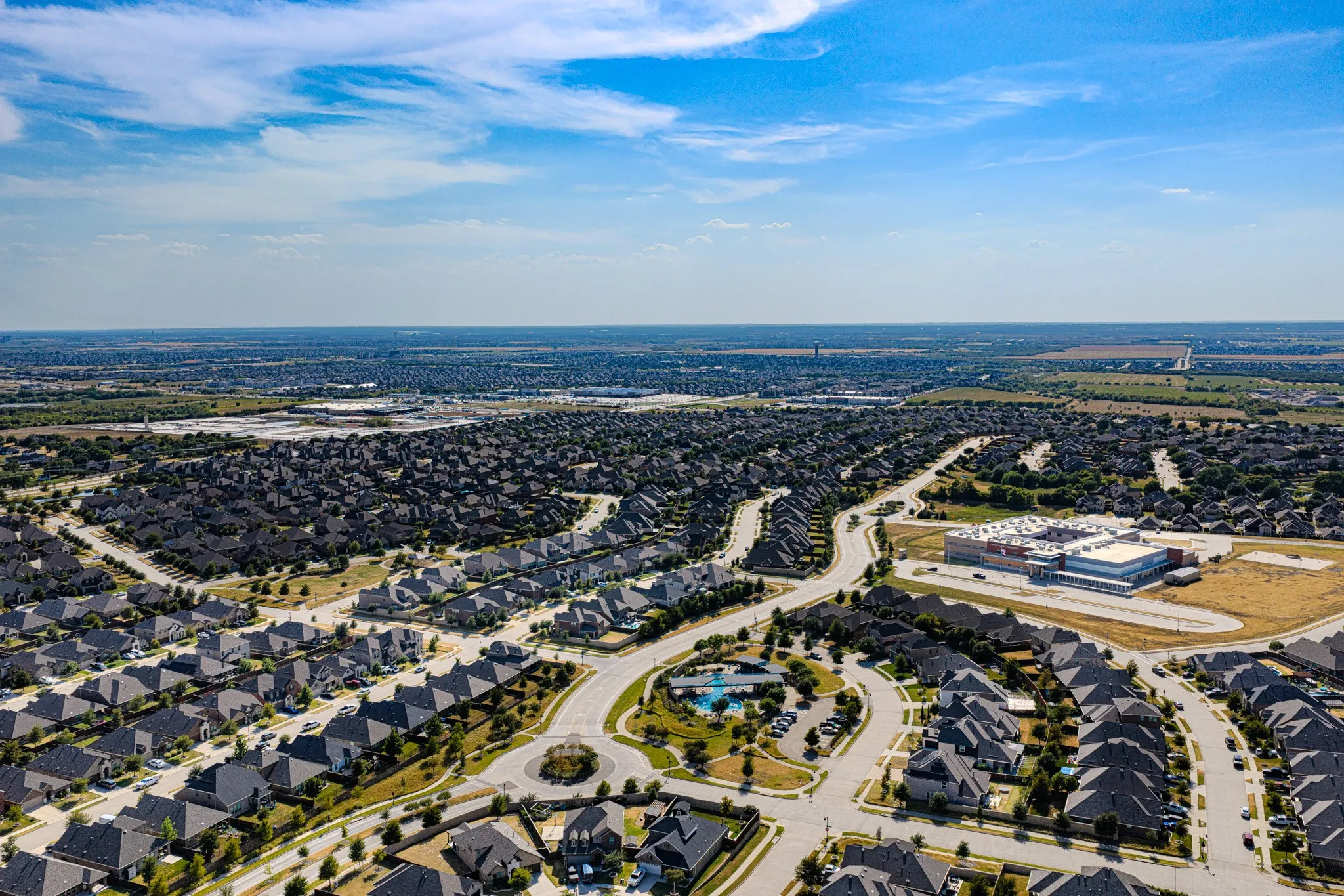 Residential community with curved streets, a central roundabout, and a community pool