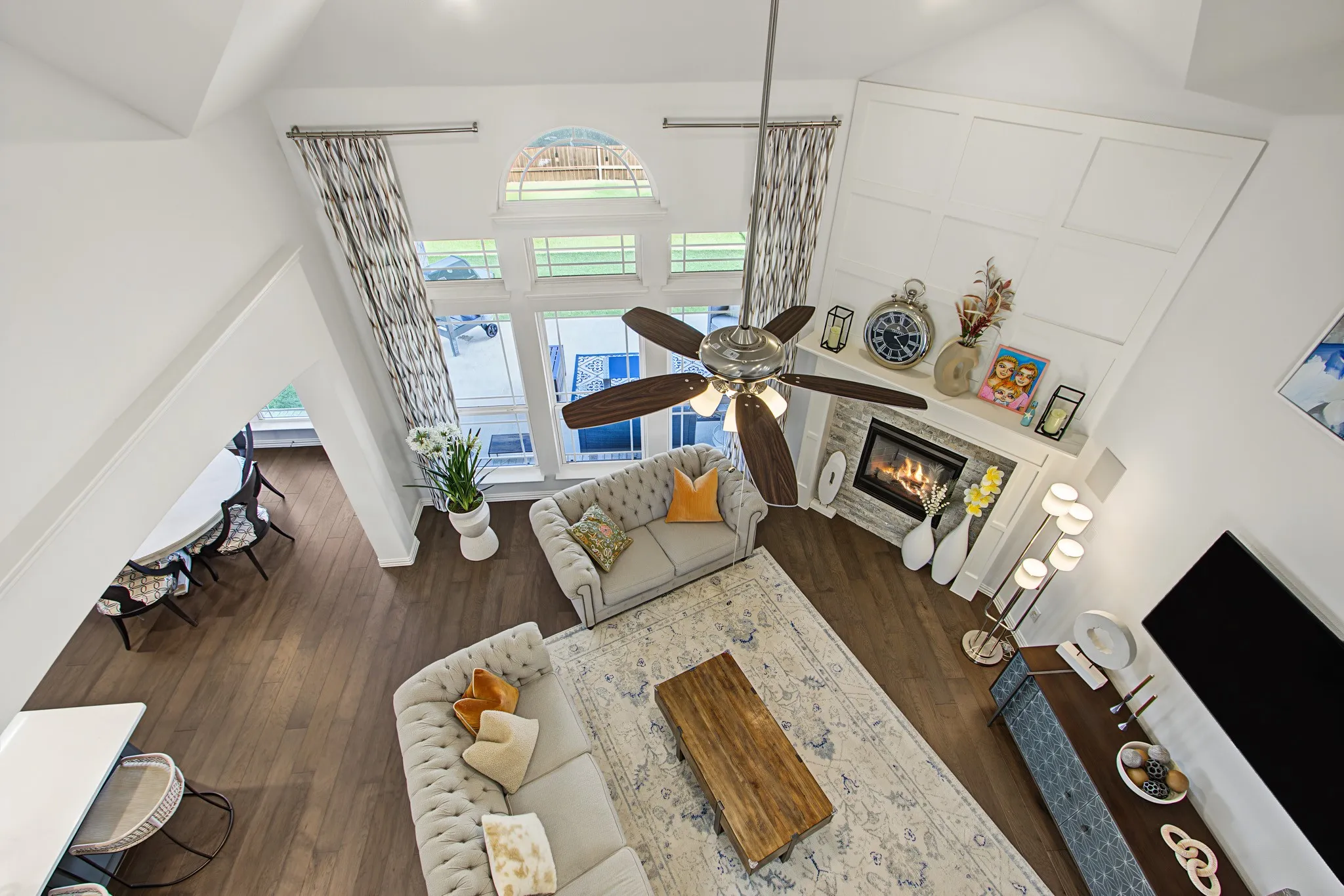 Open-concept living area with vaulted ceilings, a ceiling fan, and extensive wood-finish flooring
