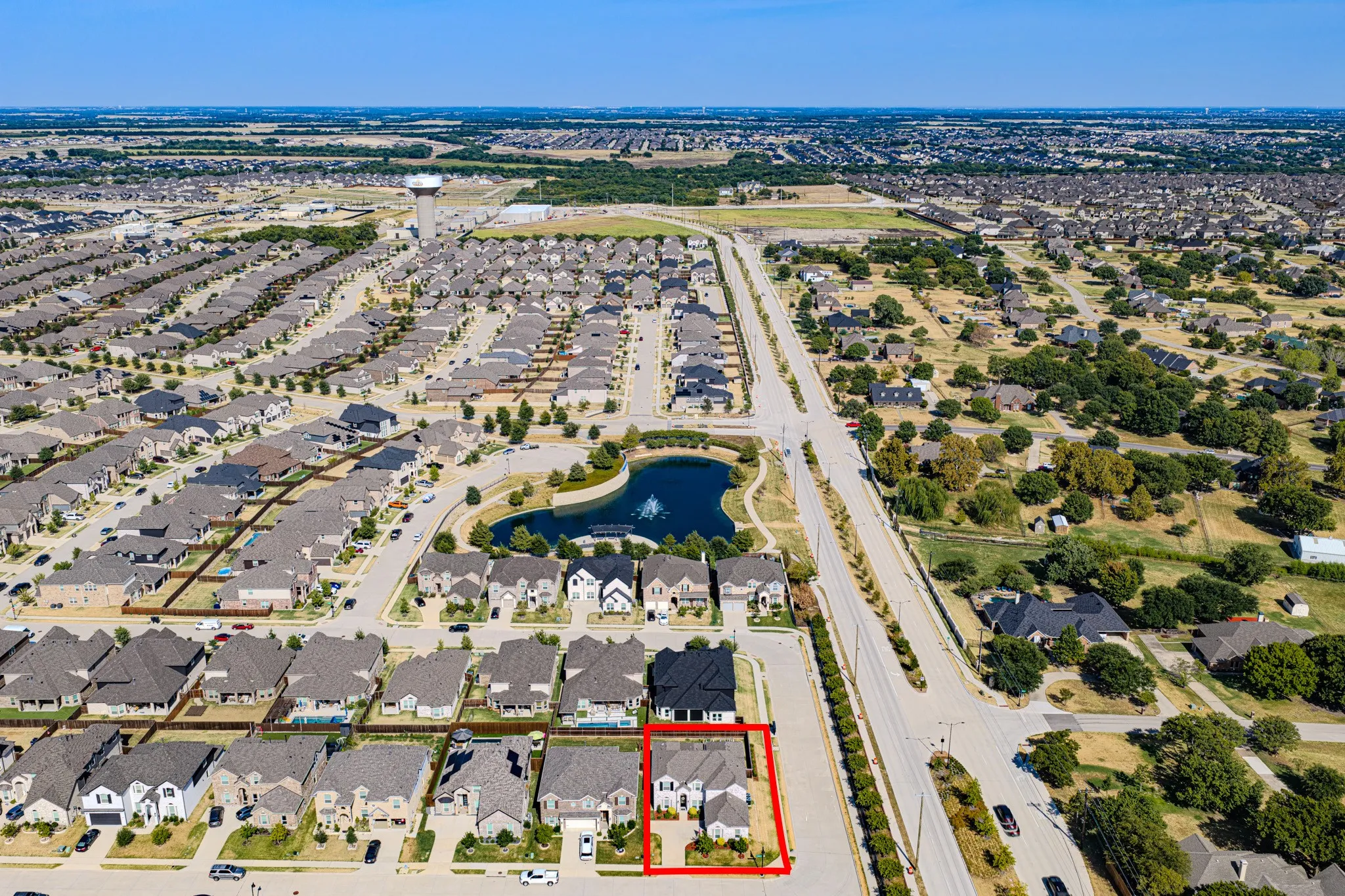 Aerial perspective showcasing subject property outline in  residential development with a central pond feature, extensive street network, and numerous single-family homes