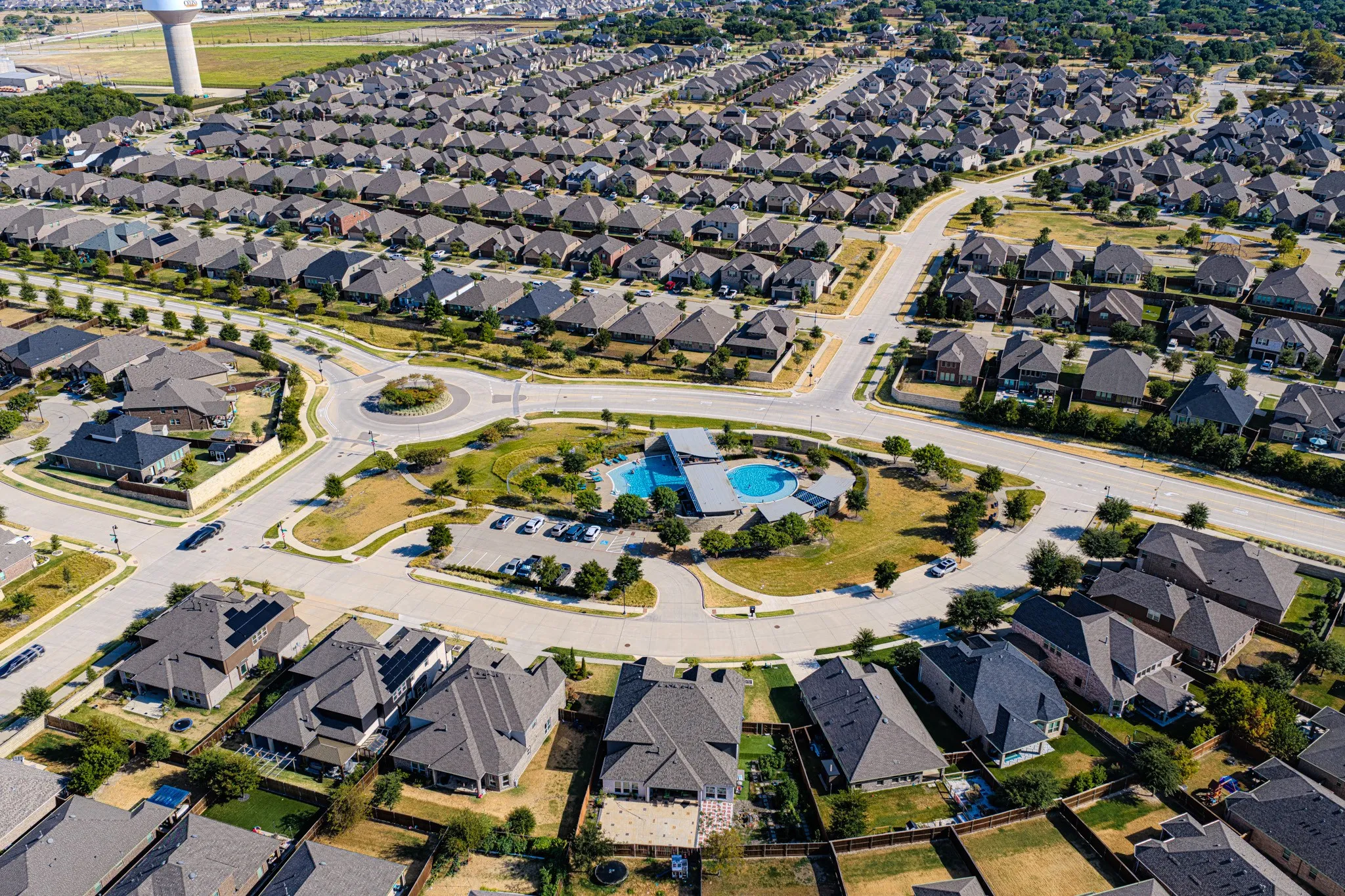 Community featuring a central roundabout, swimming pool, and dedicated parking area