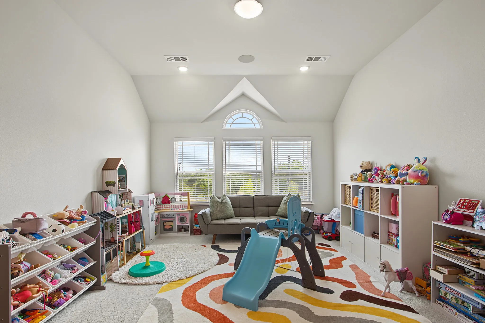 Vaulted ceiling with an arched window, recessed lighting, and three panel windows with blinds
