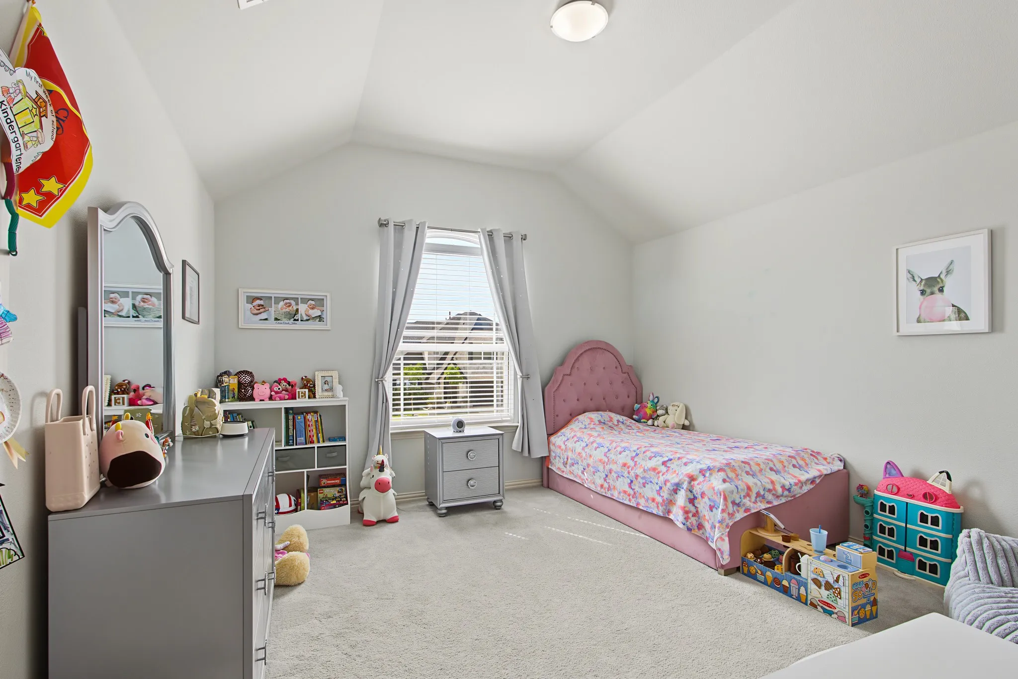 Vaulted ceiling with a flush-mount light fixture, a window with blinds, and light-colored carpeting
