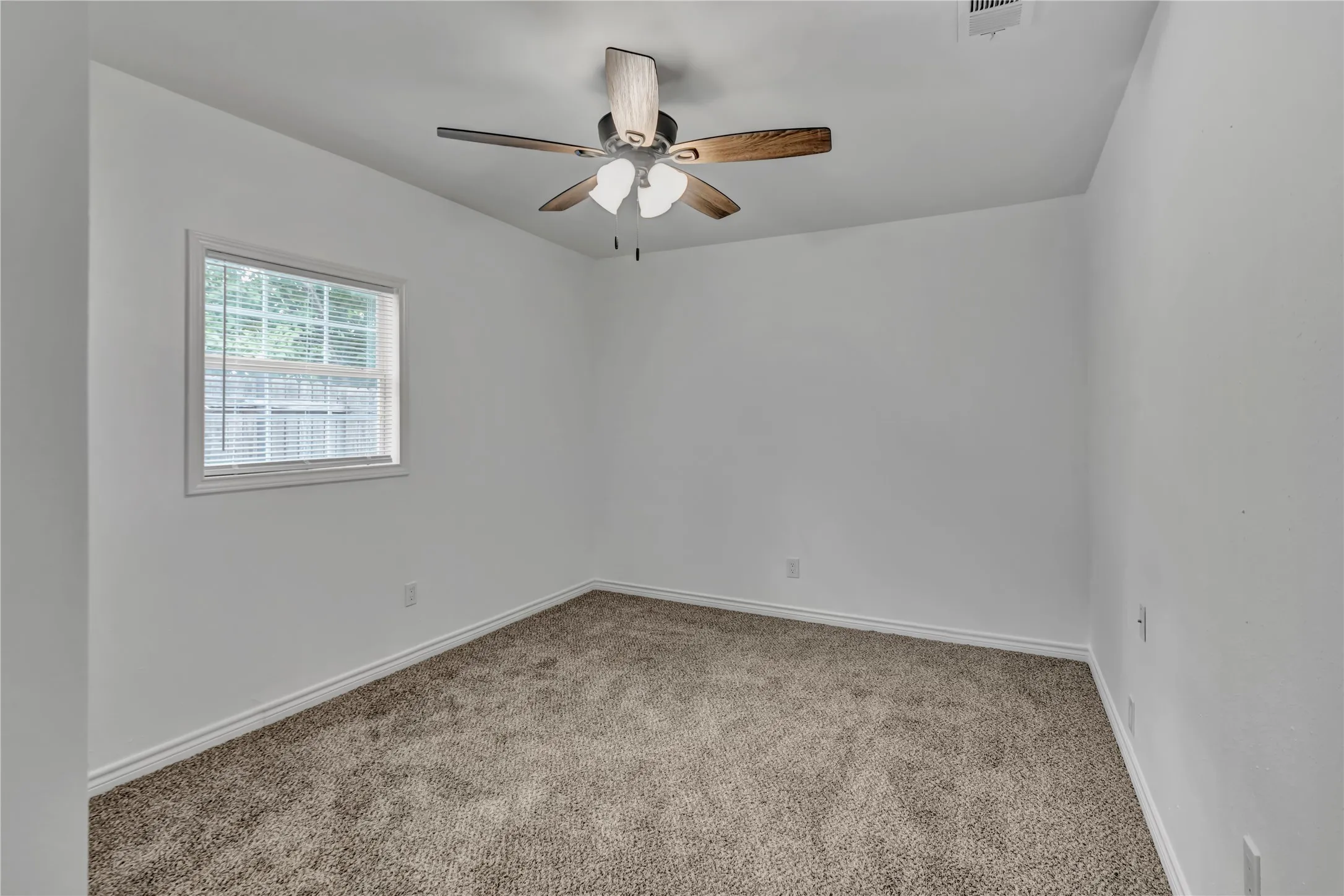 Neutral wall color, window with blinds, ceiling fan, and carpeted flooring